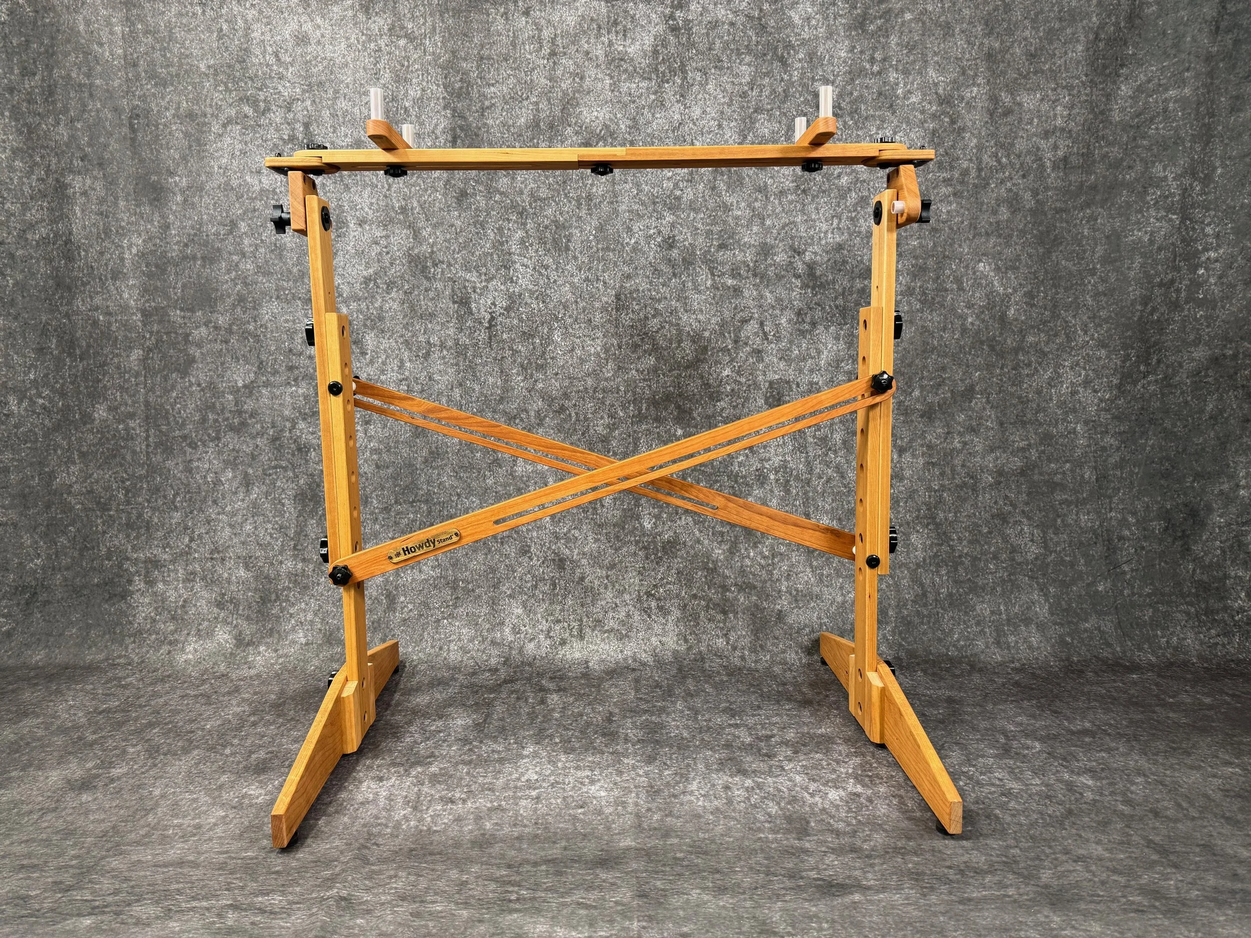A mountain dulcimer player's stand, with black knobs, in solid cherry wood.
