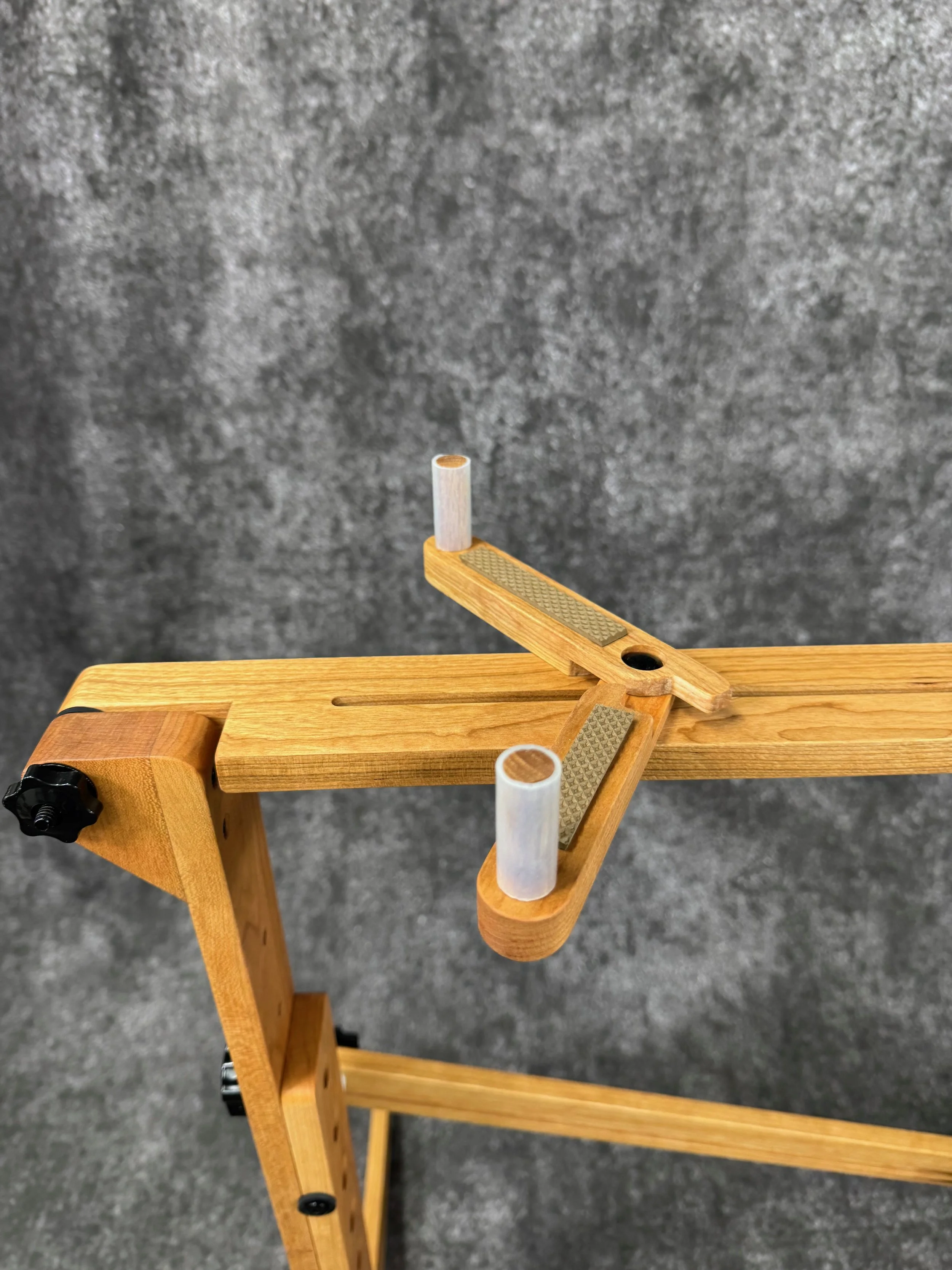 A close-up view of the end of a mountain dulcimer stand, with sliding scissor brace