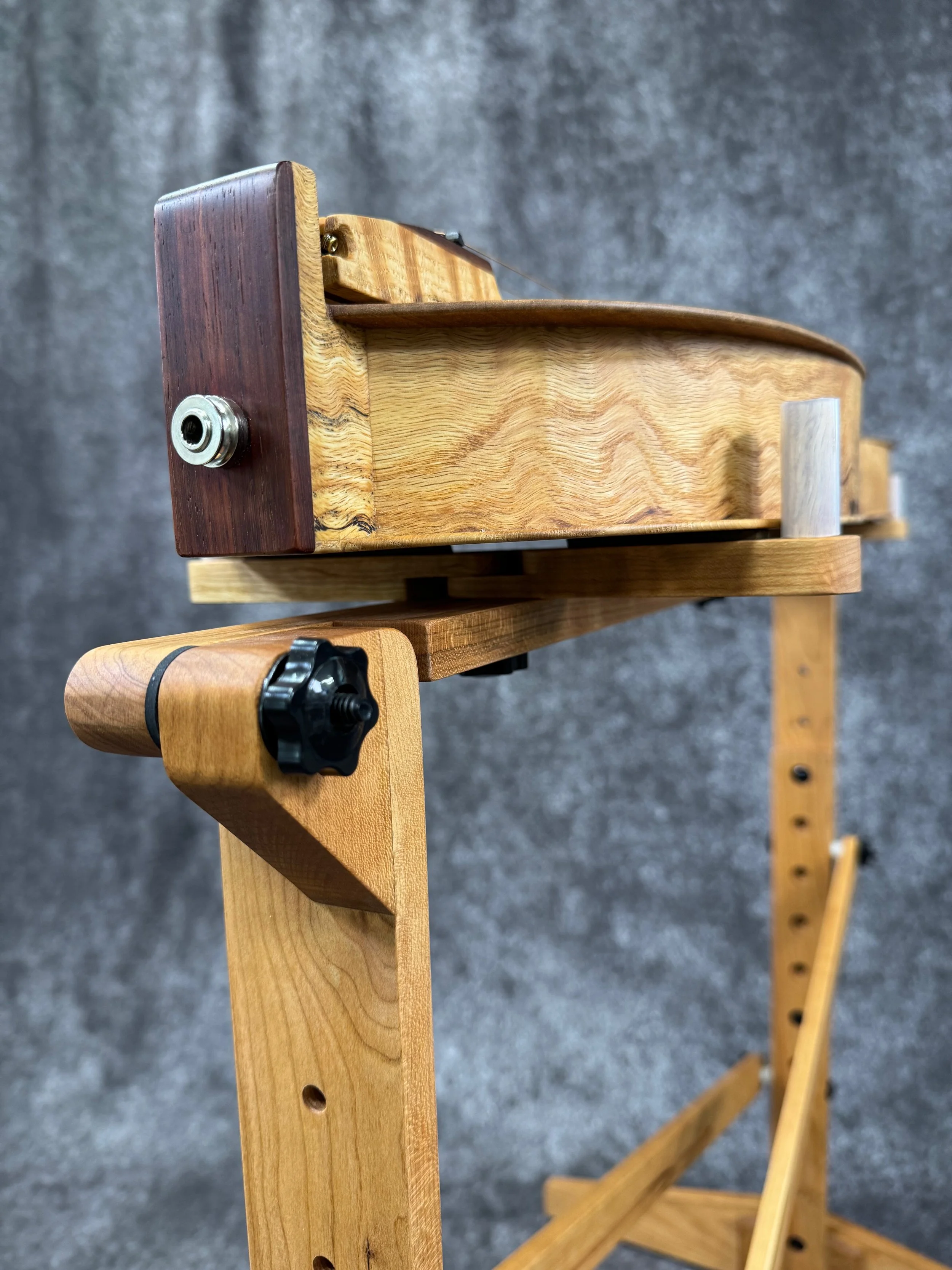 A closeup view of the tailblock end of a mountain dulcimer on a dulcimer stand.