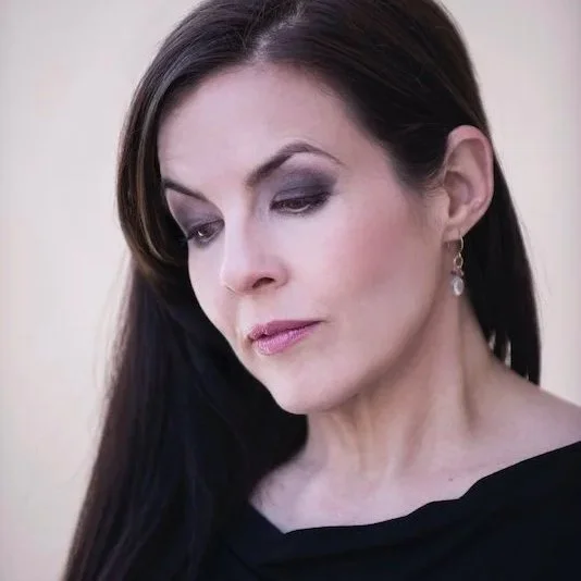Three-quarter profile portrait of Kannon, sovereign mentor, intuitive healer, guide for transformational life transitions, and founder of Asteria Lumina
