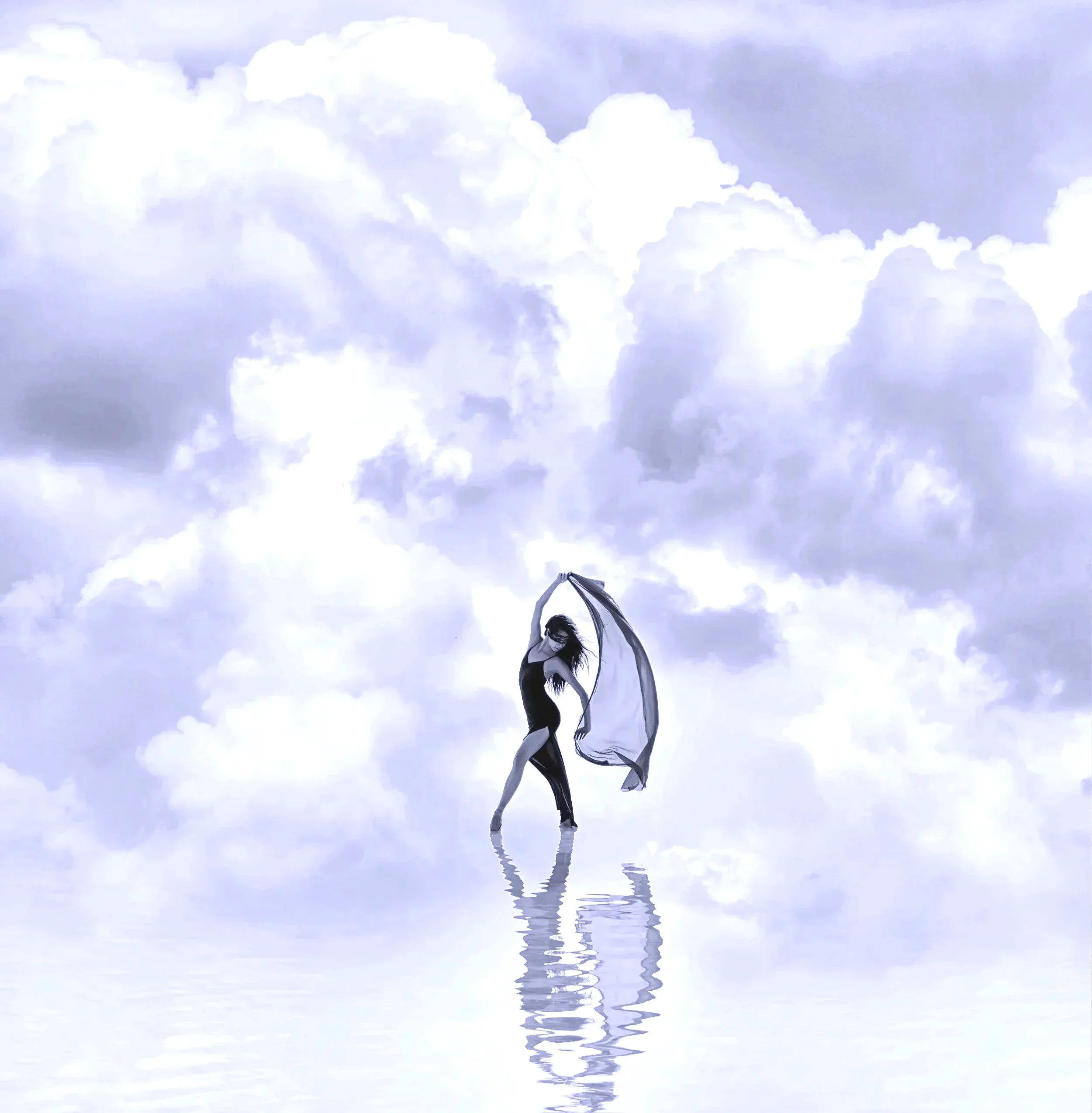 A woman with curly hair dancing with a flowing scarf in front of a cloudy sky, with her reflection visible on a body of water below representing Your Private 1:1 single clarity session or nine-session advisory.