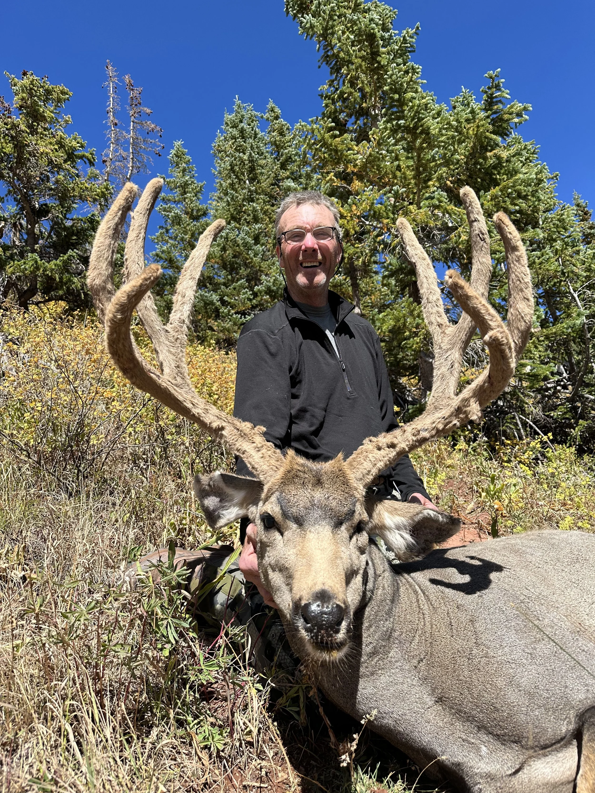 Hunter with a 200 inch plus high country mule deer from Colorado's wilderness