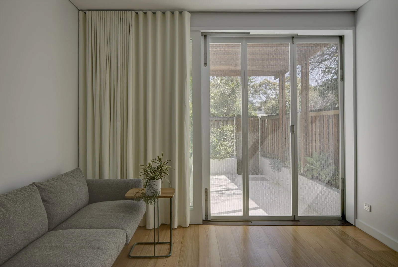 Minimalistic Living room with and sliding screen opening to a rear garden and dining area