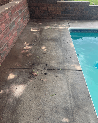 Pool concrete filled with dirt, debris and grime in need of a concrete cleaning next to a pool!
