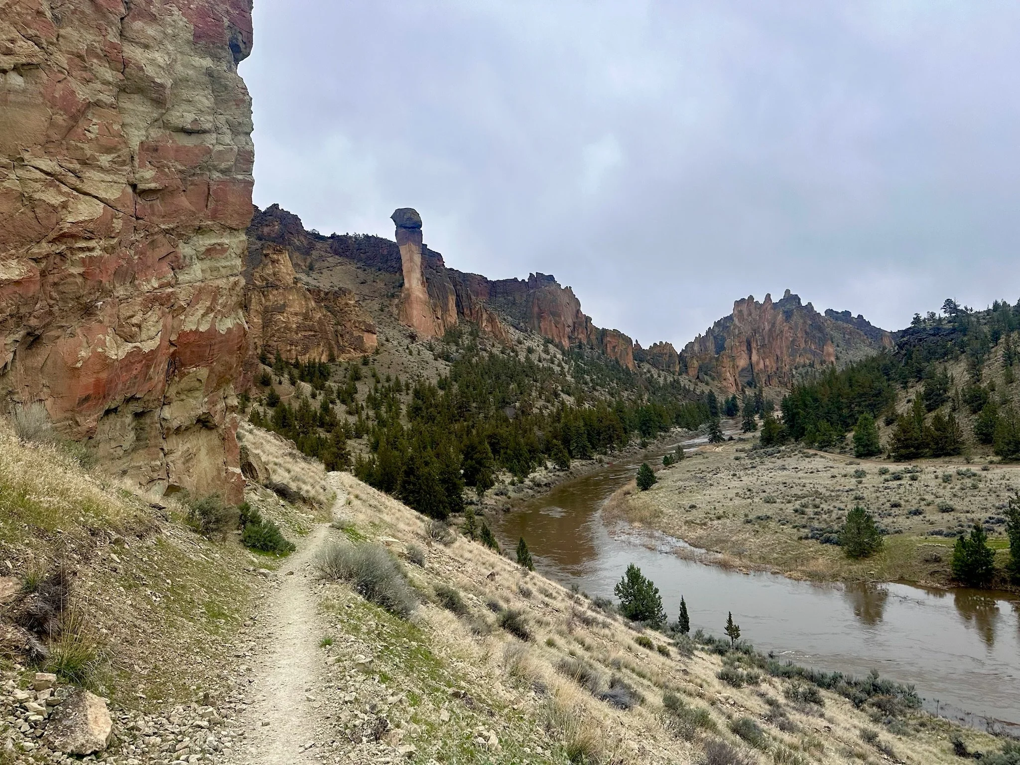Hiking trail along a river canyon at Smith Rock State Park in Oregon, representing movement and progression along a path