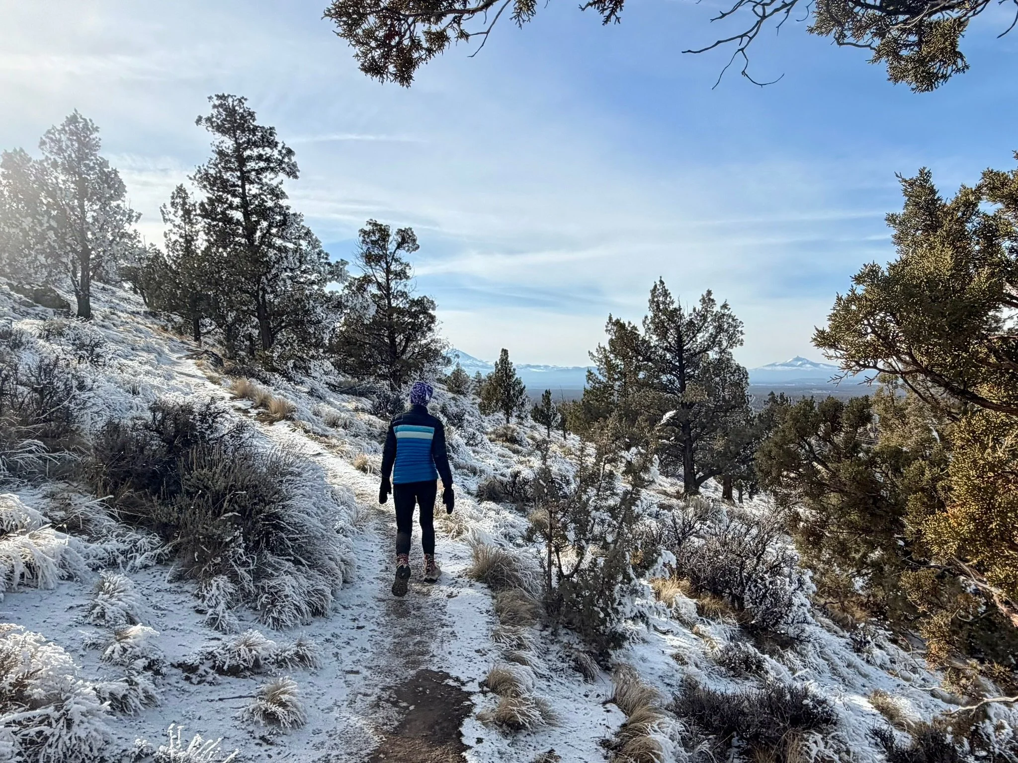 A woman walking along a snowy trail from behind, representing everyday movement and strength as part of heart health in midlife.