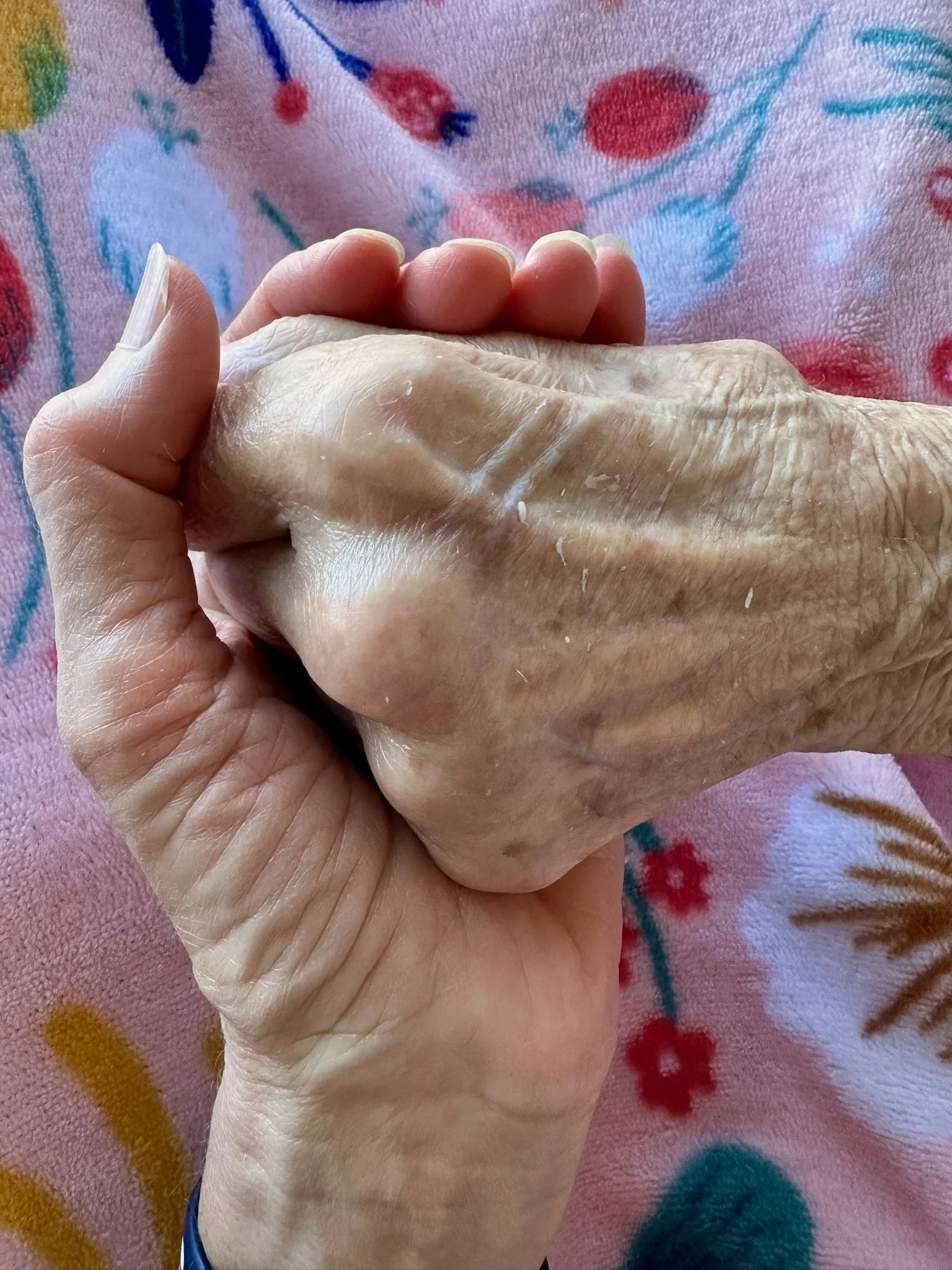 Adult daughter holding her elderly mother’s hand, symbolizing love, caregiving, connection, and the later stages of life.
