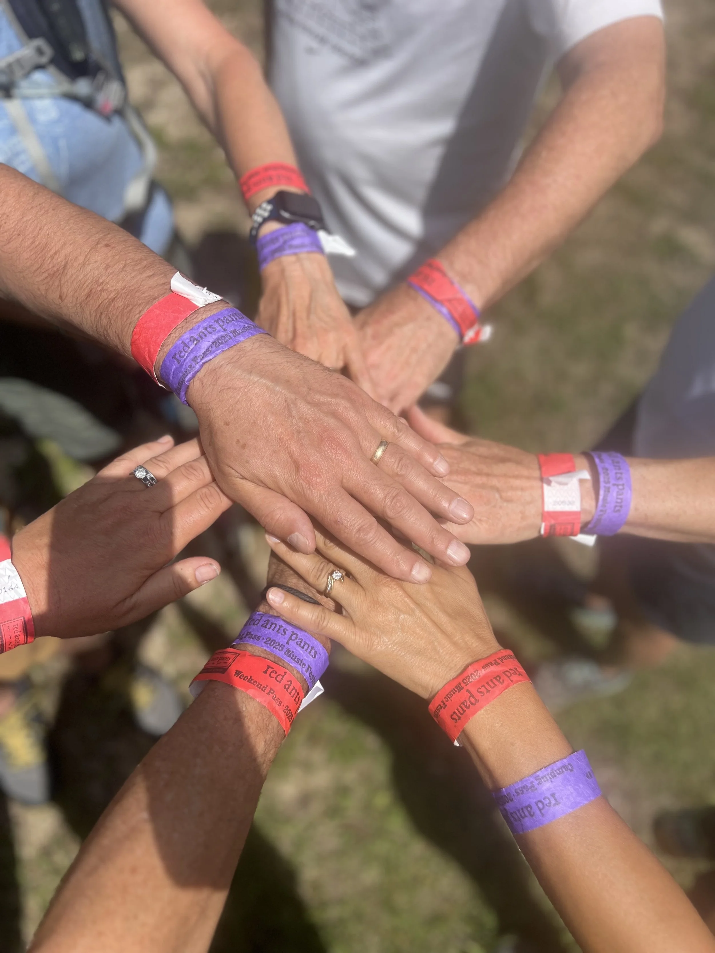 Hands stacked together, symbolizing connection, support, and community as essential to heart health in midlife.