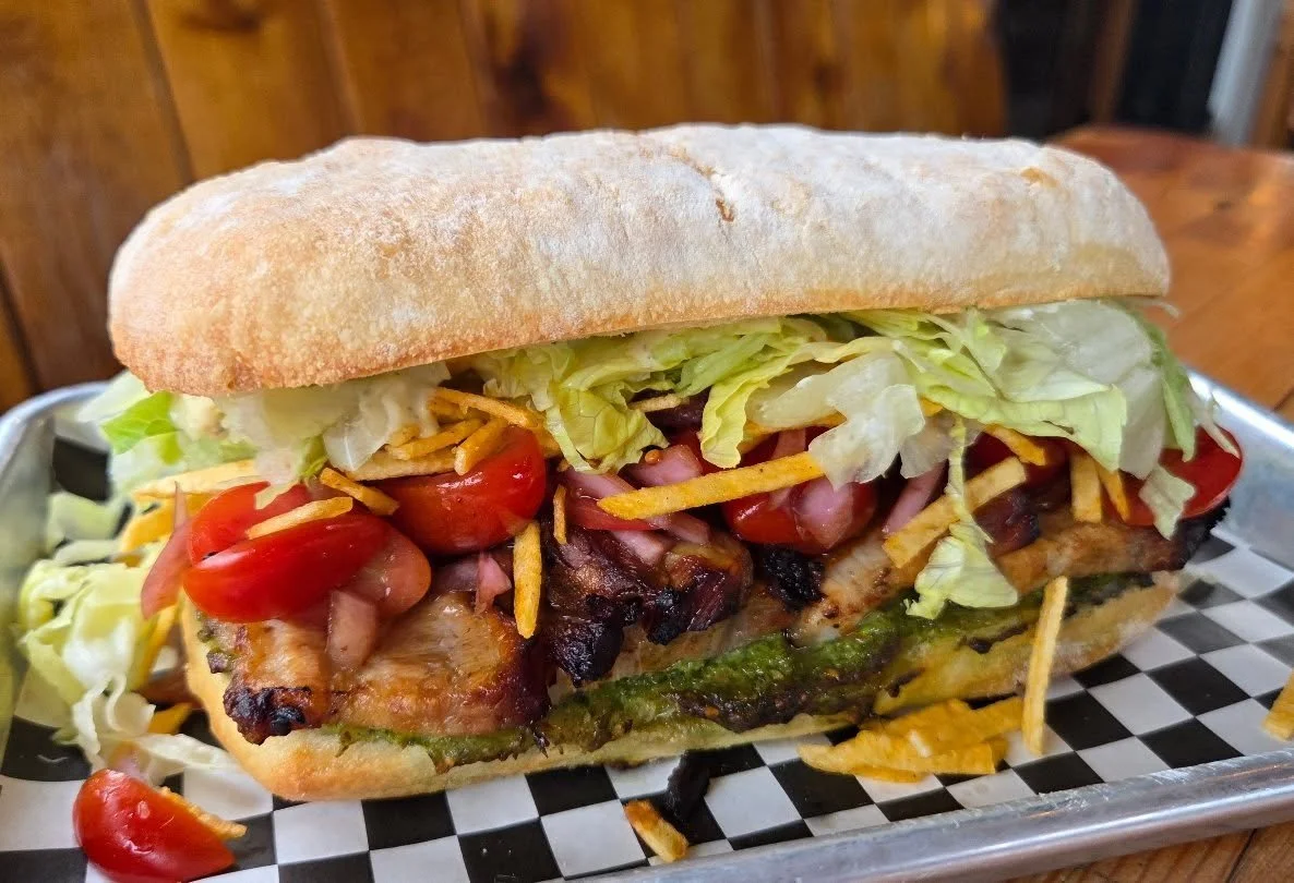ROCK BAY L.T
Smoked pork belly, pesto, balsamic tomatoes n red onions, hickory sticks, shredduce and dill pickle mayo.
A classic sandwich with a hood twist. Maybe wash it down with a Rock Bay Yall. Our house made ice tea with a lil vodka in it. Up to