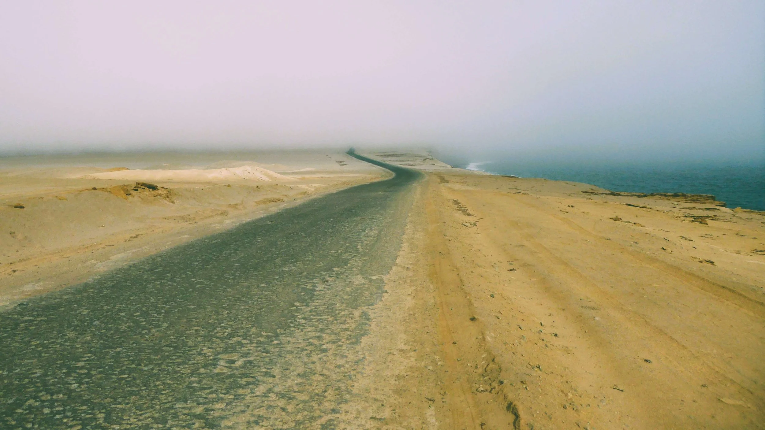 The road along the cliffs above Playa Roja disappearing into the distance at the Paracas National Reserve, Peru
