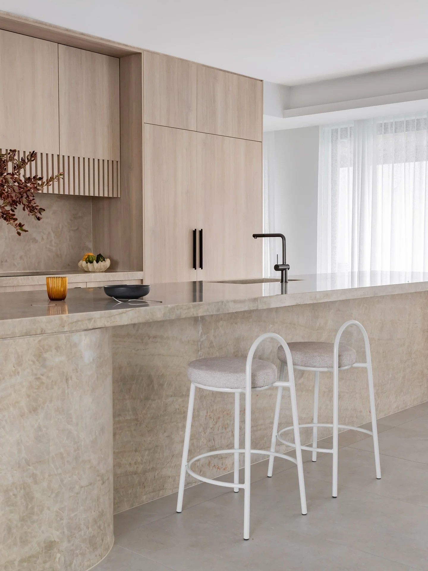 A kitchen designed for quiet impact.
Warm timber, layered stone, and gentle forms work together to create a space that feels calm, grounded, and highly considered.
A tonal palette and restrained detailing bring softness and structure to the heart o