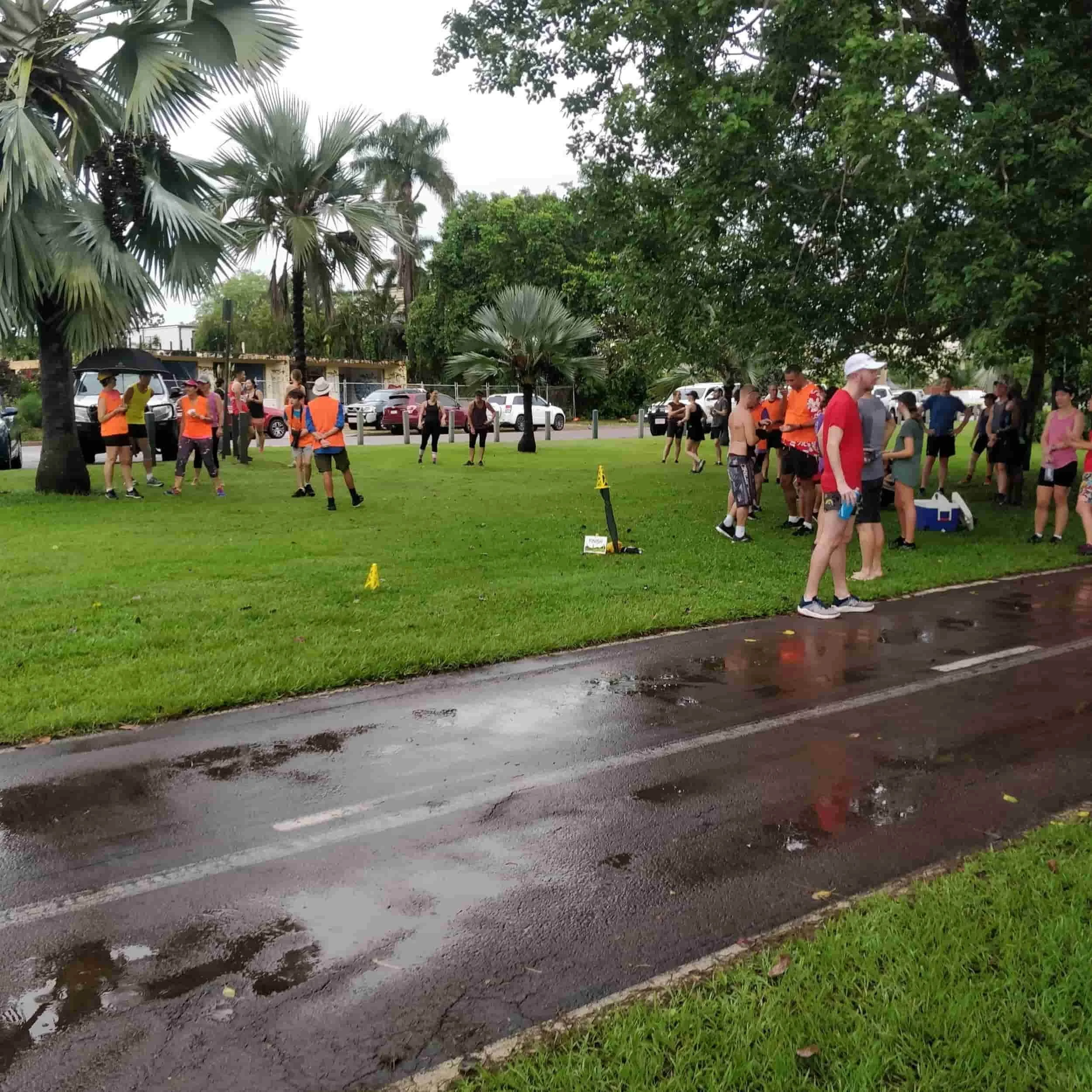 A collective of runners and walkers on a damp road, reflecting the camaraderie of Adventure Physio's Nightcliff Parkrun.