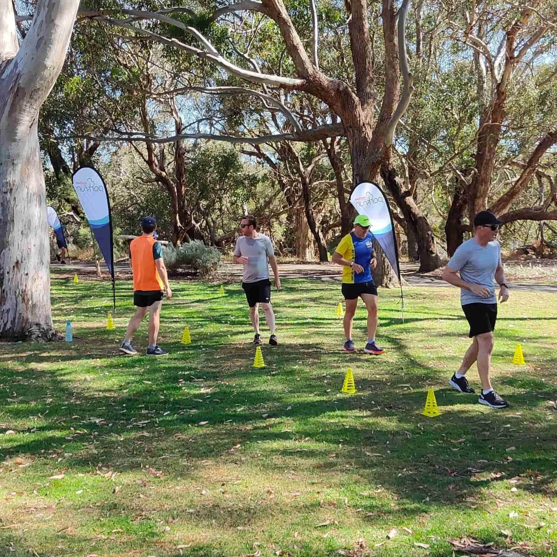 A diverse group of Bibra Lake residents running together in Bibra Lake WA Parkrun, promoting community and fitness through Adventure Physio.