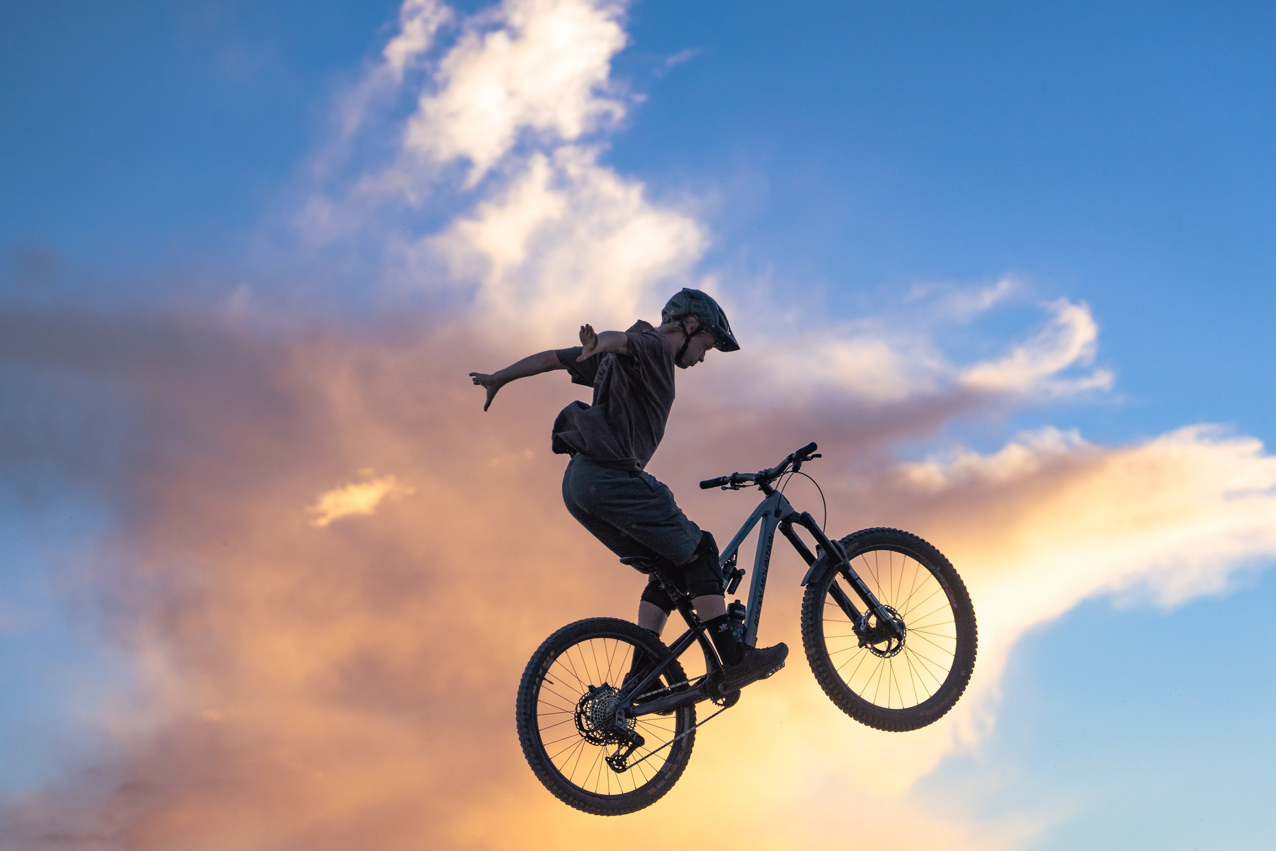 Silhouette of a cyclist performing a jump on a mountain bike against a sunset. | Photography by Anders Henrikson Photo 