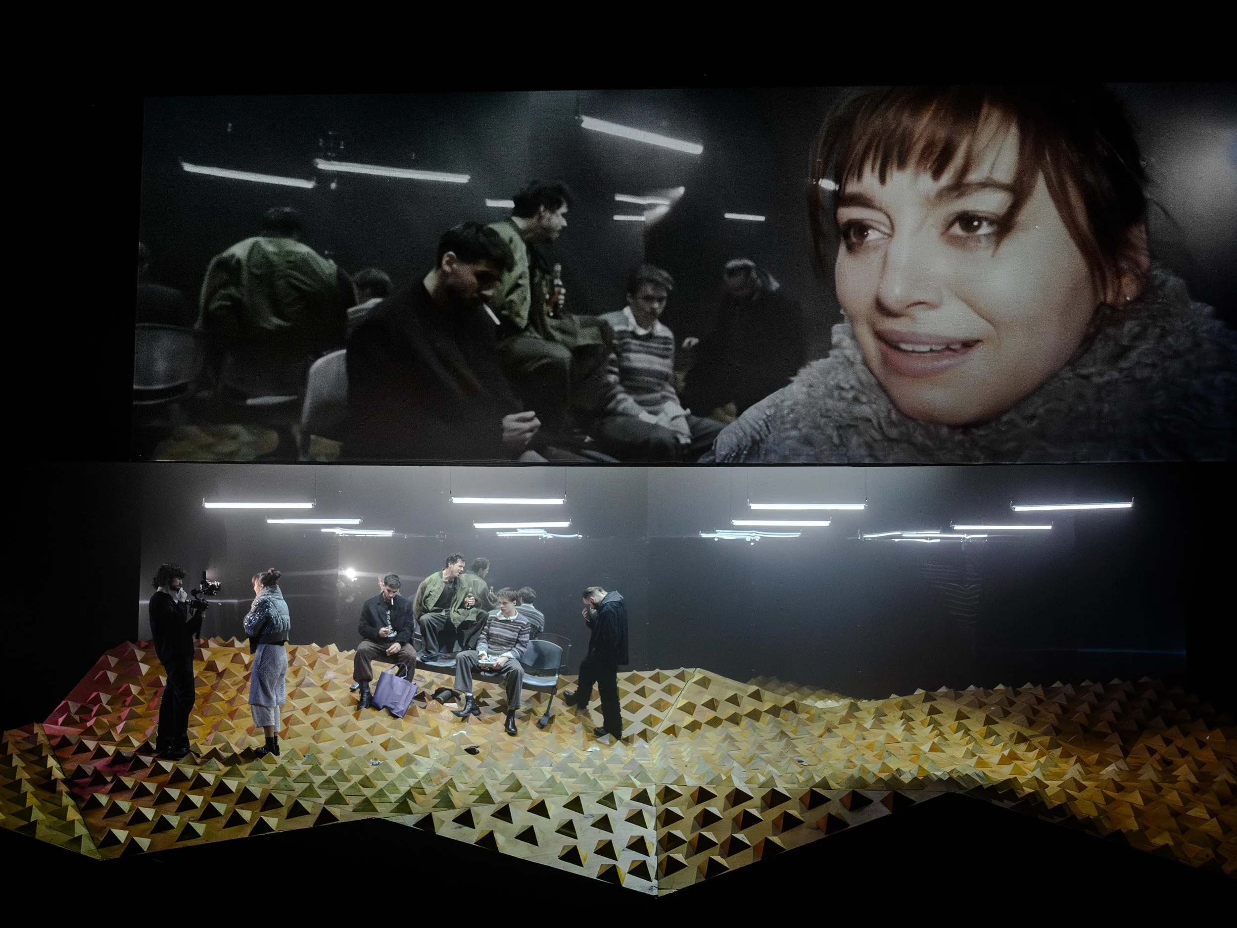 Zwei Bilder eines Filmschaffens-Setups. Das obere Bild zeigt eine Szene mit mehreren Schauspielern, darunter eine junge Frau im Vordergrund, die auf einer dunklen Bühne sitzt. Das untere Bild zeigt die gleiche Szene aus einer anderen Perspektive, mit