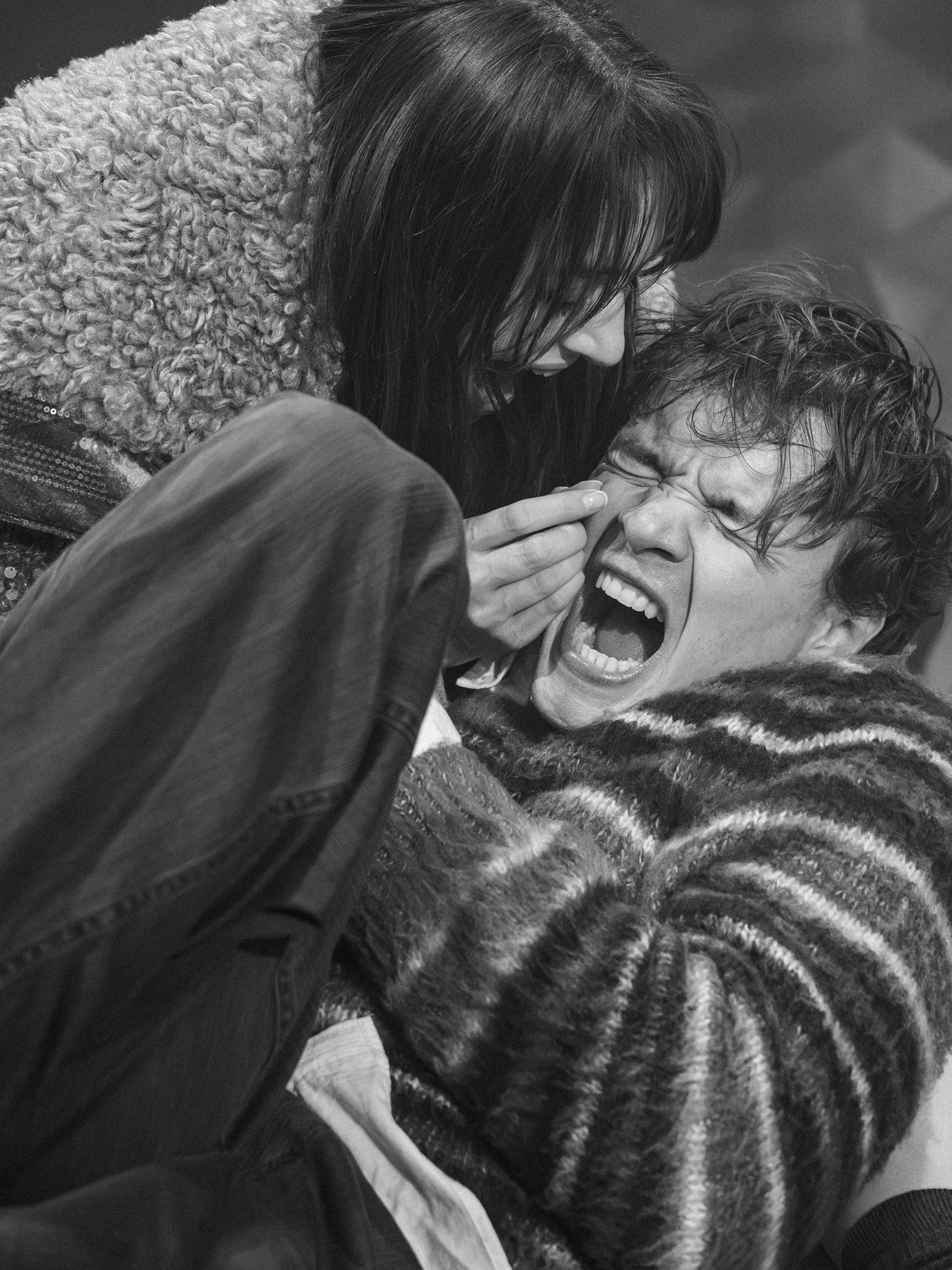Zwei Menschen in einem emotionalen Moment, eine Person schreit vor Schmerz oder Angst, die andere Person versucht zu trösten oder zu helfen.