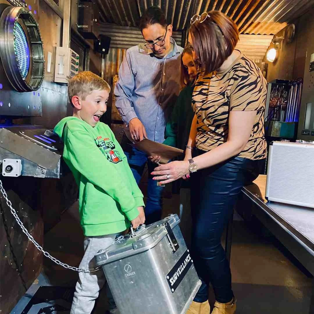 A kid picks up a prop with his family in an escape room