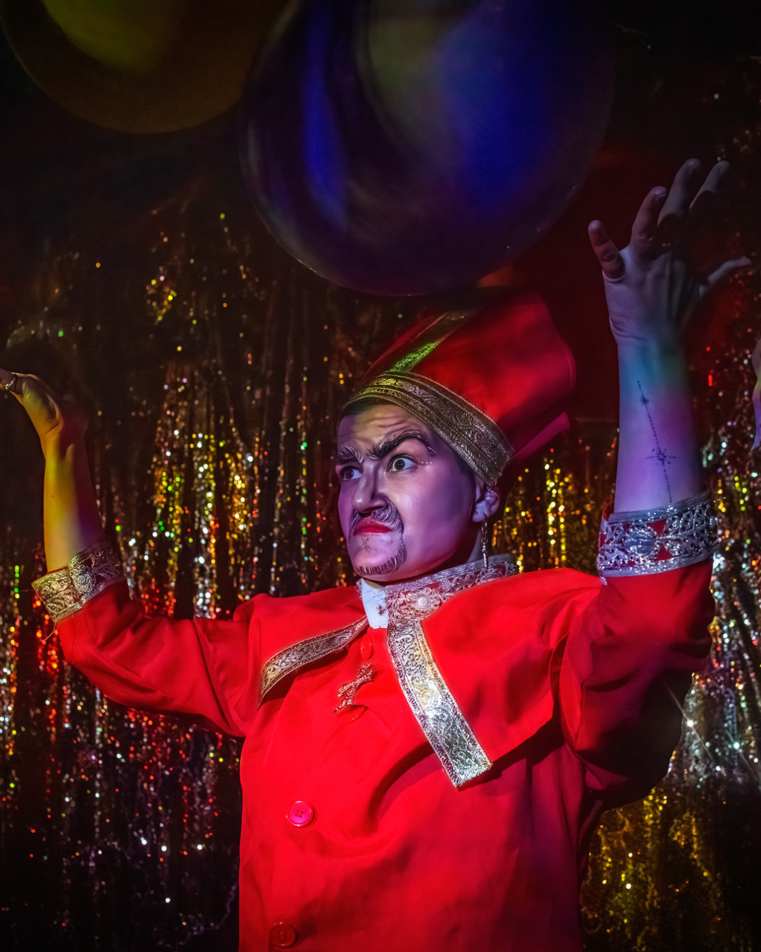 woman in drag as a priest in a red robe