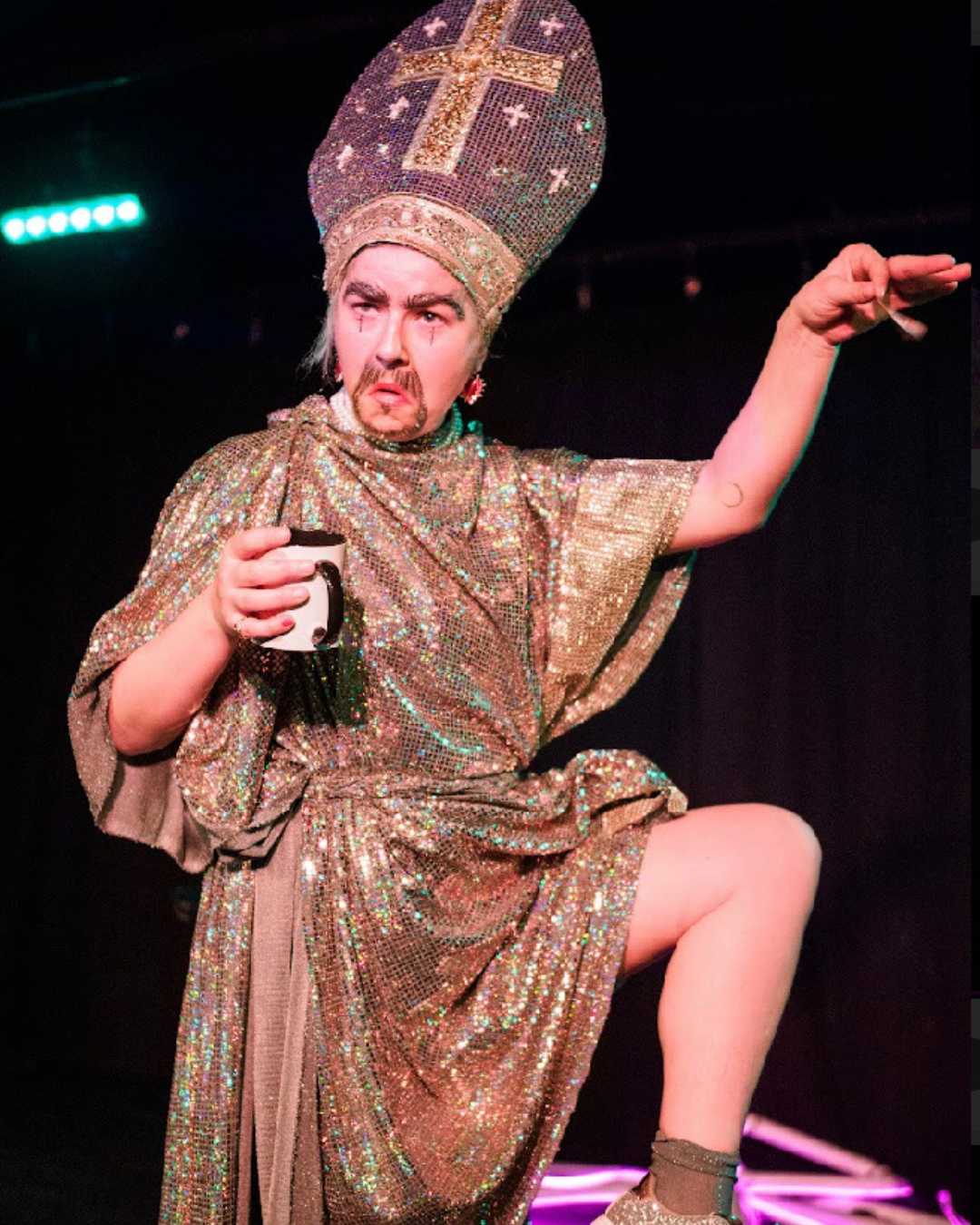 woman in drag as a priest in a glittery robe and beard