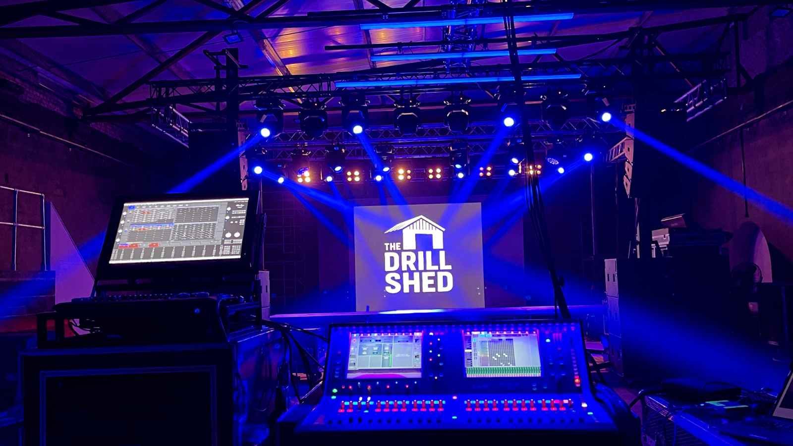 mixing desk view over a stage with the drill shed on it