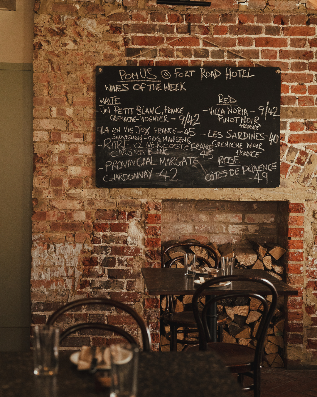 chalk board of wines above a fireplace