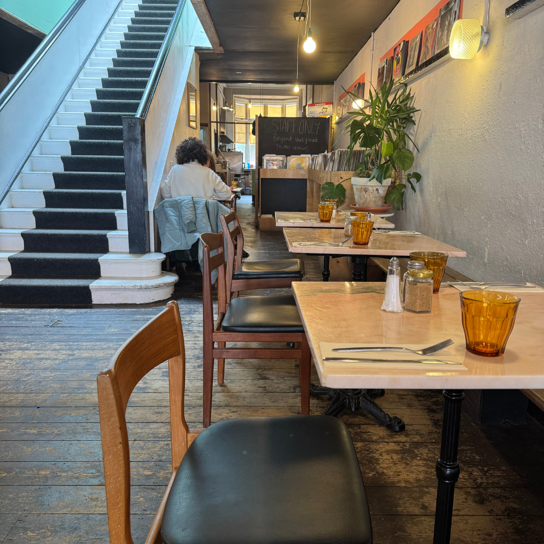 Row of chairs and tables of 2 with pink marble top in a cafe