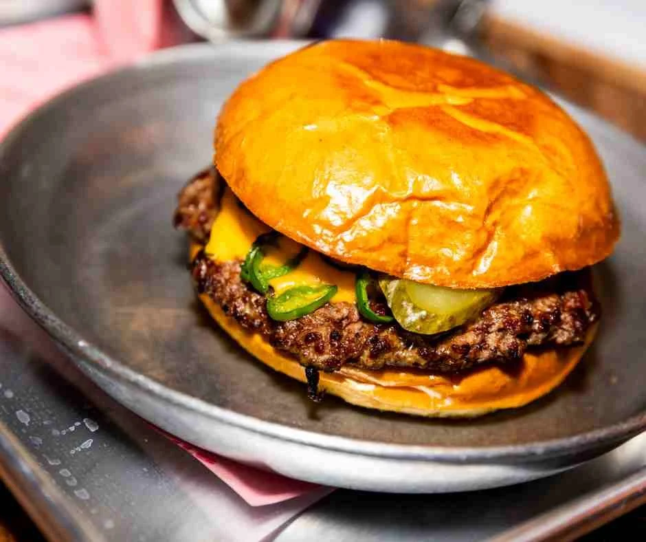close up of a burger on a stainless steel platter
