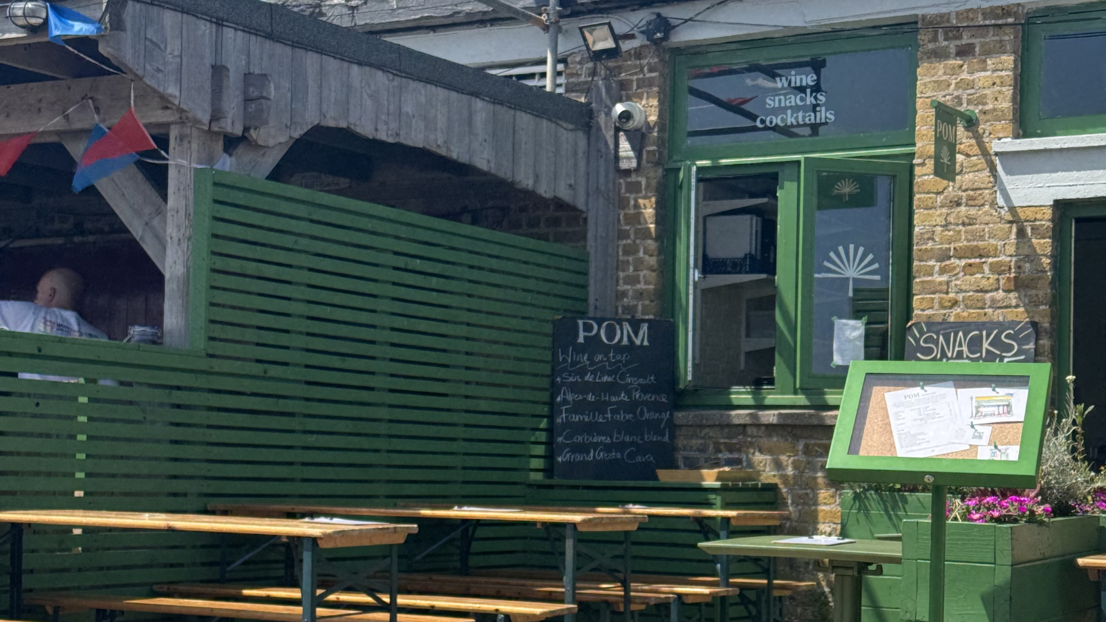 Green small restaurant with benches outside
