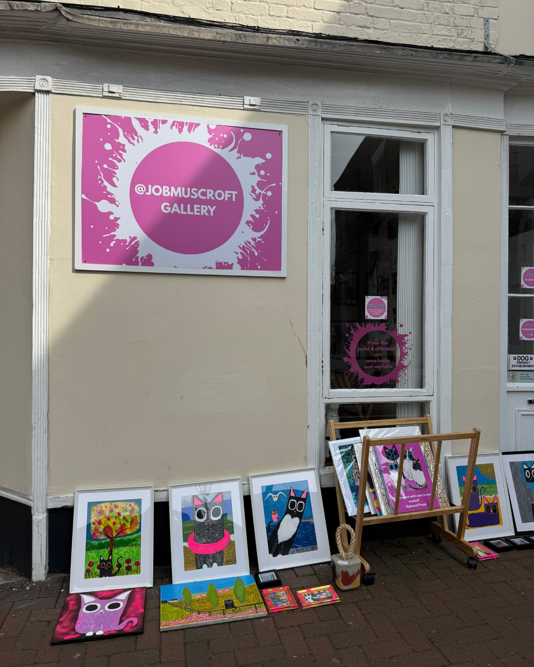 GAllery with cat art leaning outside it