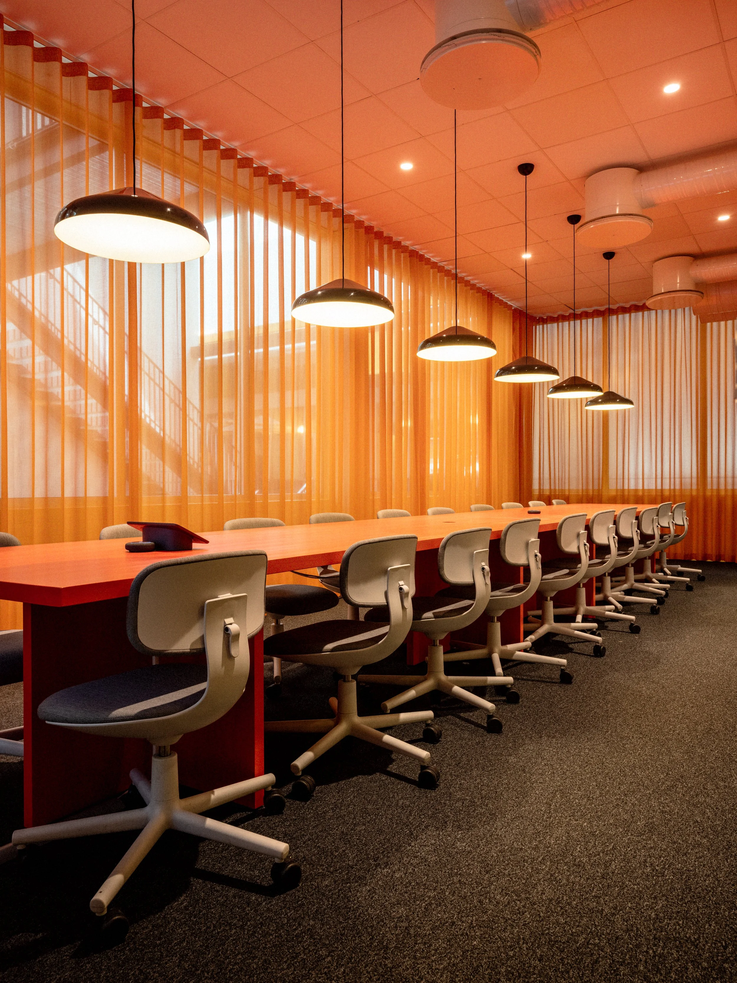 Mötesrum med orangea gardiner och stolar från vitra hos Telavox.