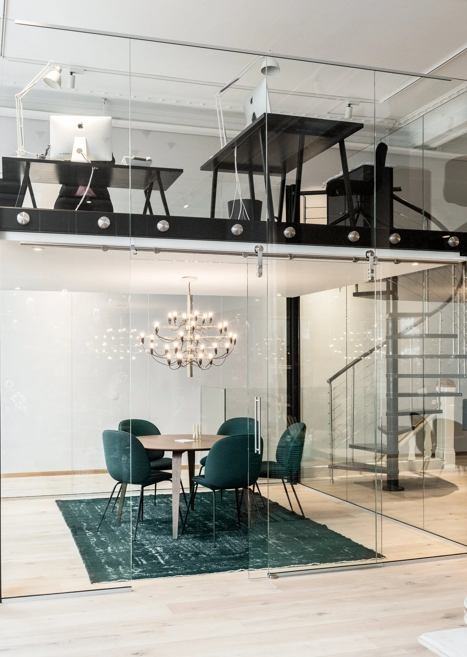 Meeting room with chairs from Gubi and a pendant lamp from Flos.