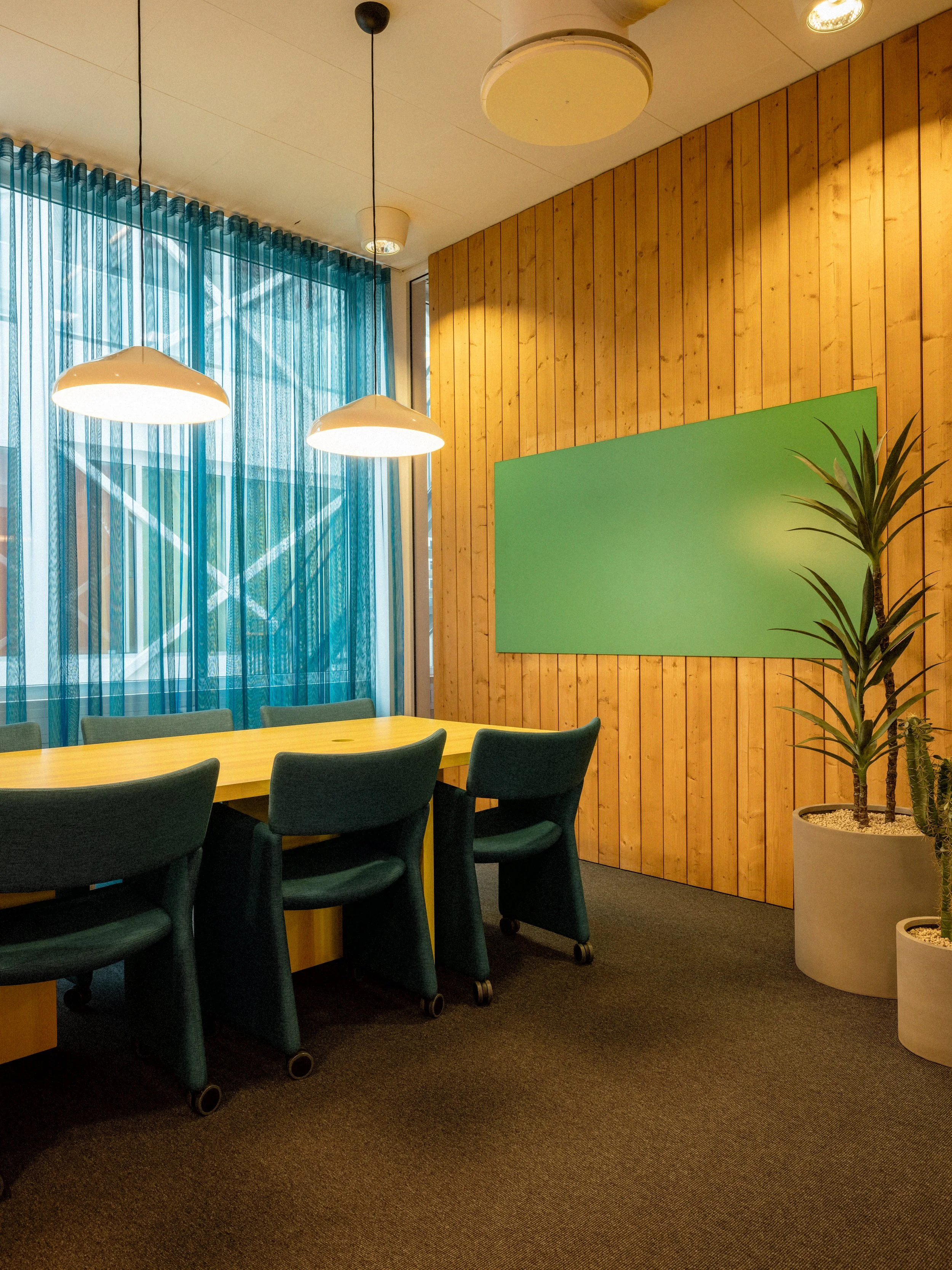 Mötesrum med grön skrivtavla och gult mötesbord samt stolar från massproductions.