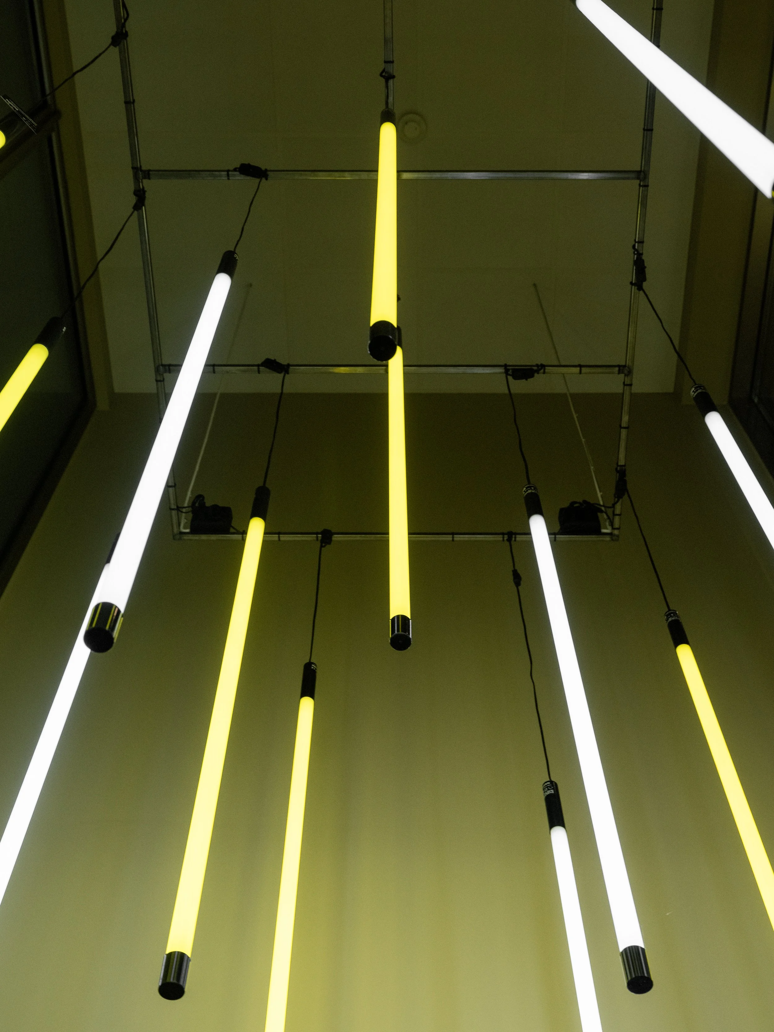 Detail of pendant lighting in stairwell with vertical light tubes