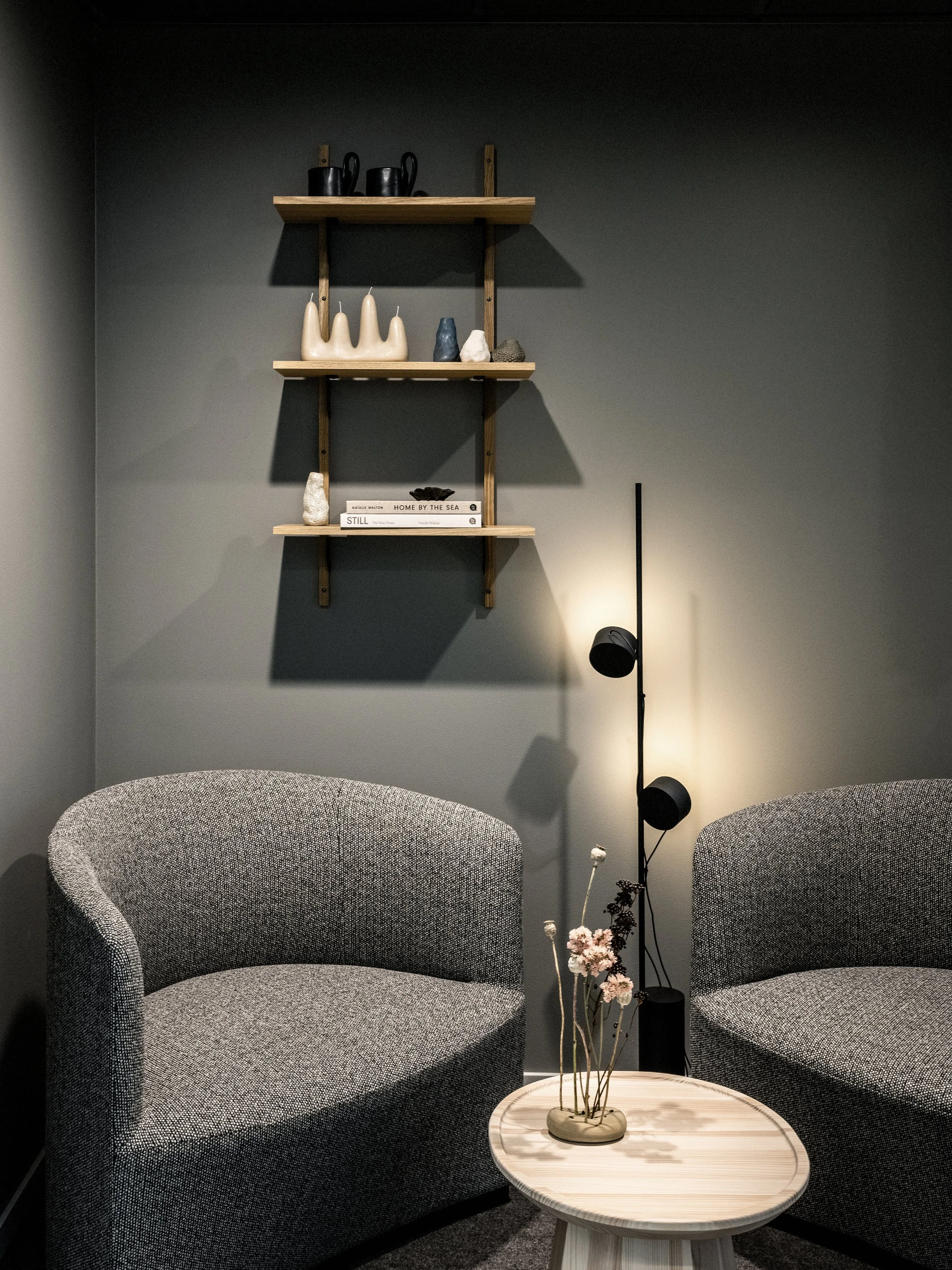 Samtalsrum med golvlampa från Muuto och vägghylla i ek.