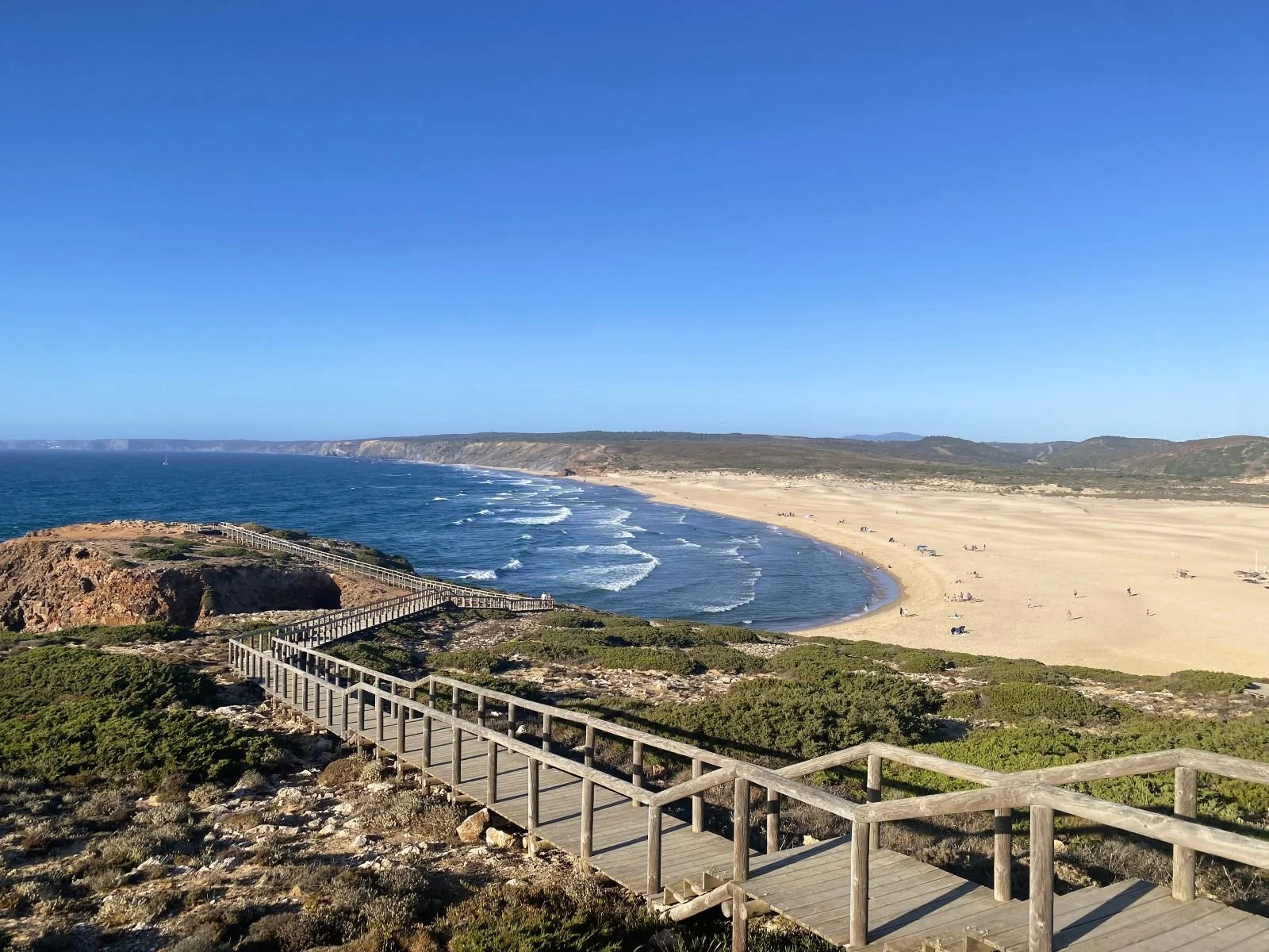 Blick von oben auf die Praia Dona Ana bei Lagos mit goldgelben Felsen, Sandstrand und Badegästen im August.