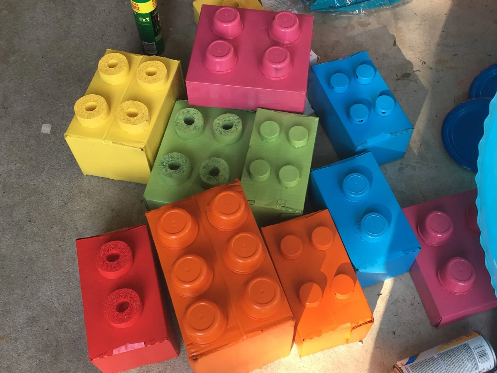 Colorful plastic building blocks arranged on a concrete surface.