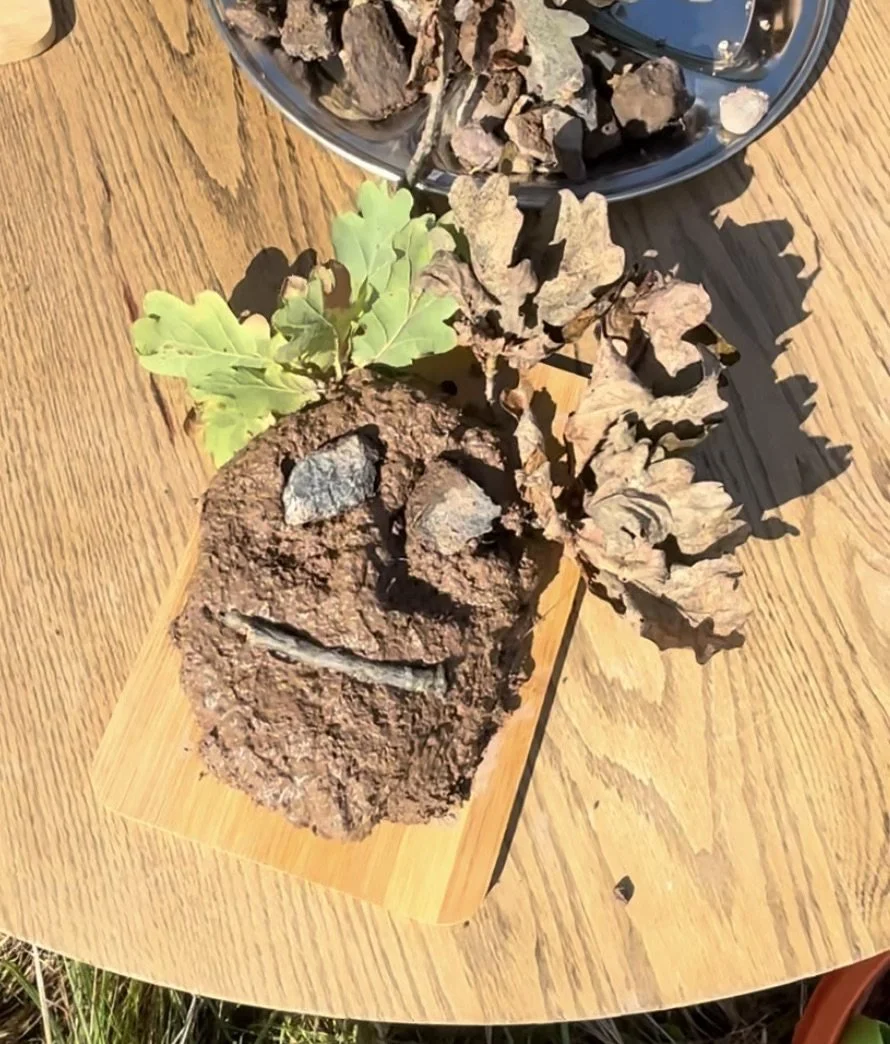 A small potted plant with a mixture of green and dried leaves placed on a wooden table.