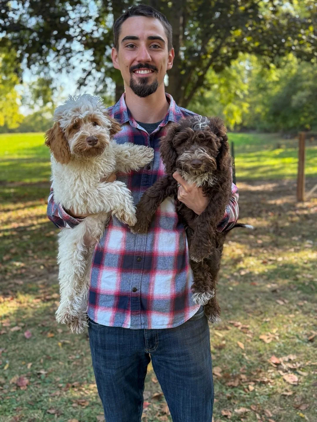 Jason Walls holding two Australian Labradoodle puppies in Anderson, Indiana