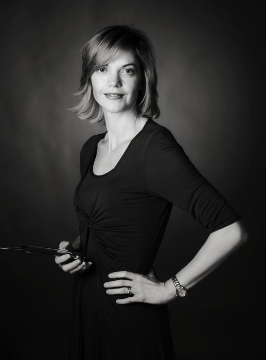 Professional photo of a woman in a dark coloured suit.