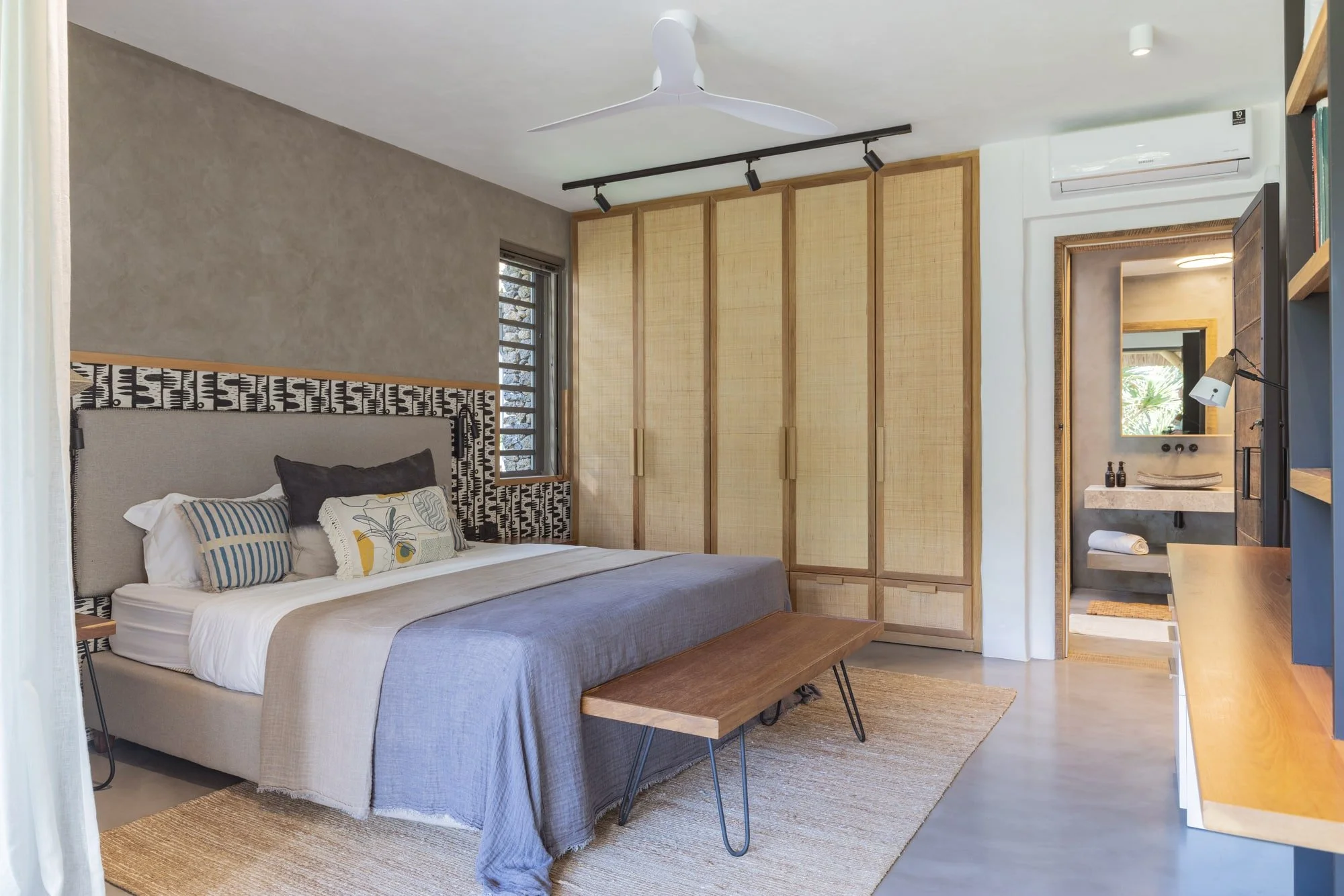 Calm guest bedroom with rattan wardrobes and natural woven textiles