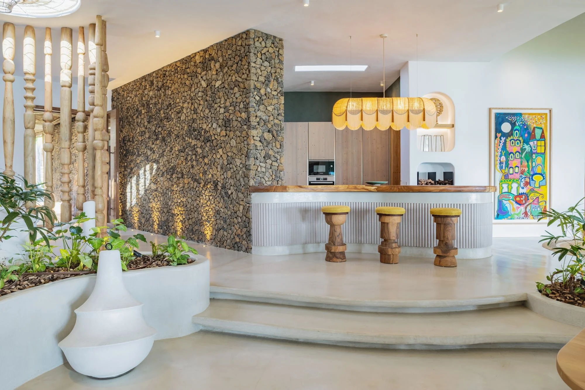Contemporary kitchen with a natural stone feature wall and curved bar