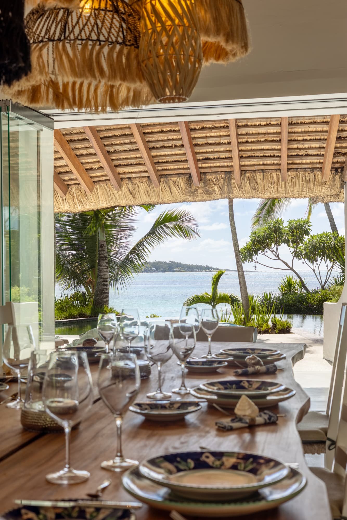 Dining table set for guests with an open view towards the lagoon