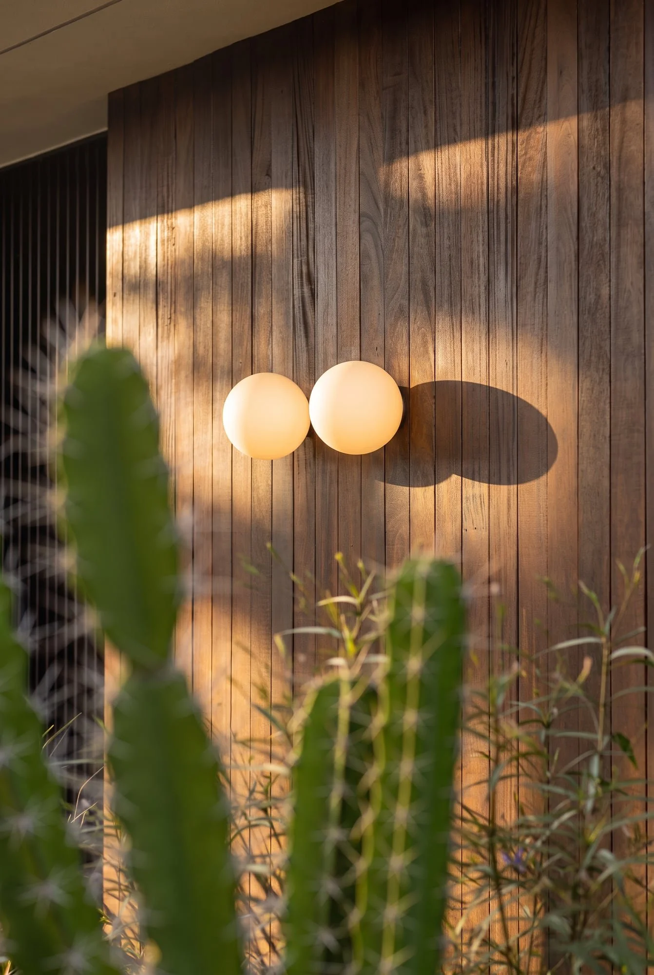 Timber cladding and globe wall lights at Krono Residence