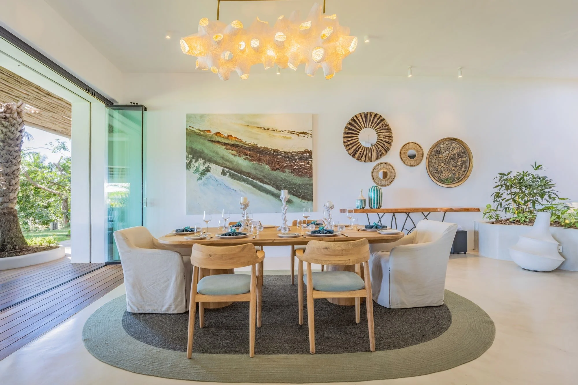 Contemporary dining area with coastal artwork and statement lighting