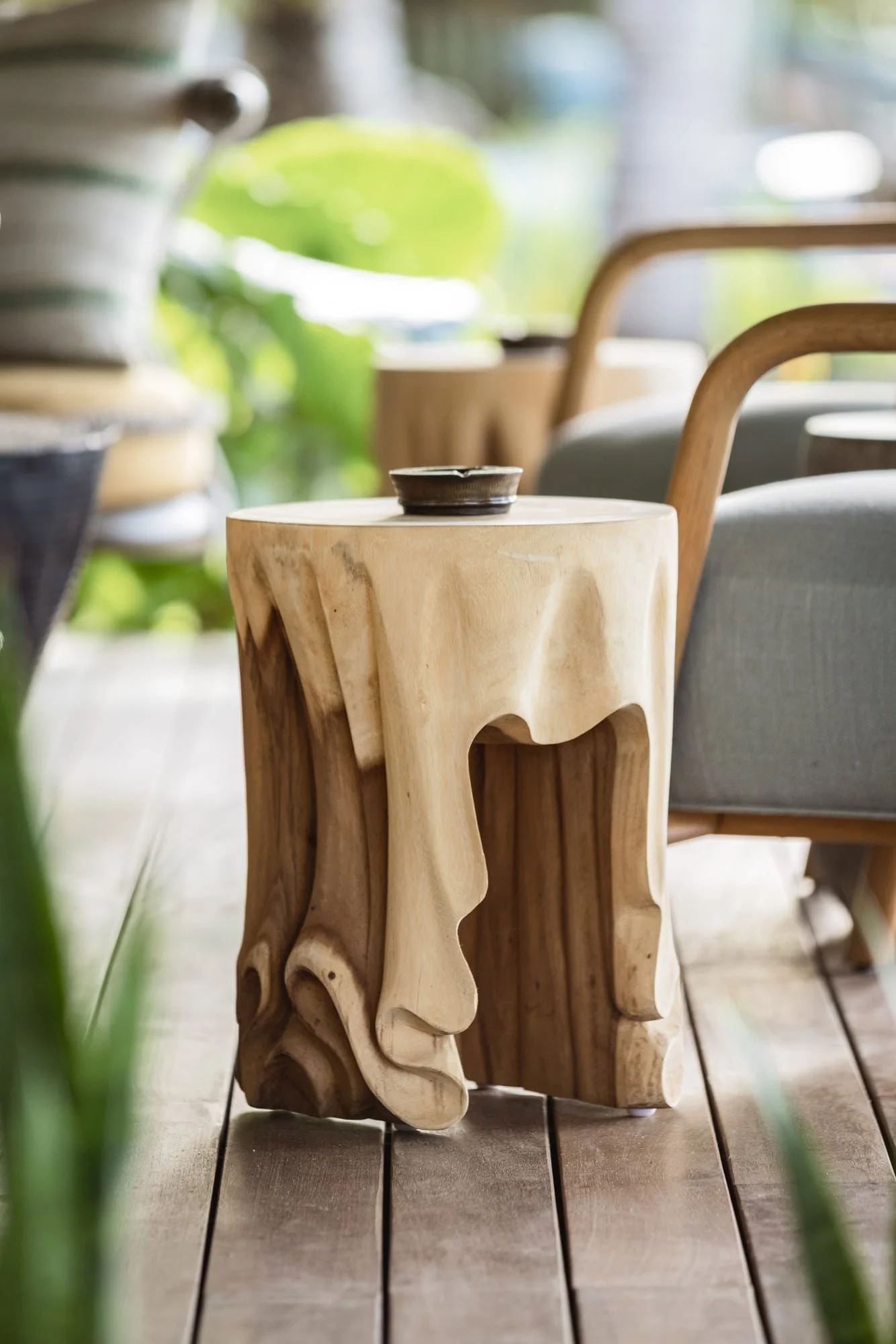 Sculptural timber side table beside contemporary outdoor seating