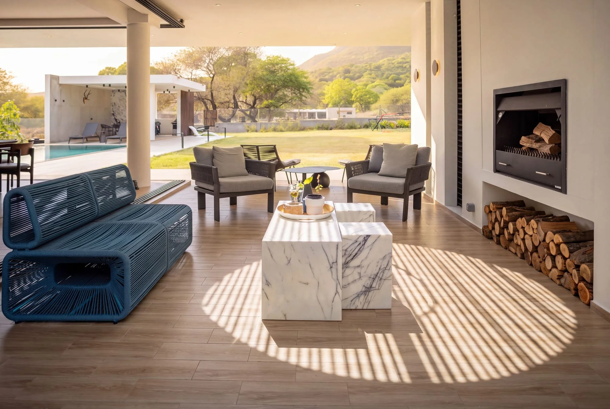Covered terrace lounge with fireplace at Krono Residence