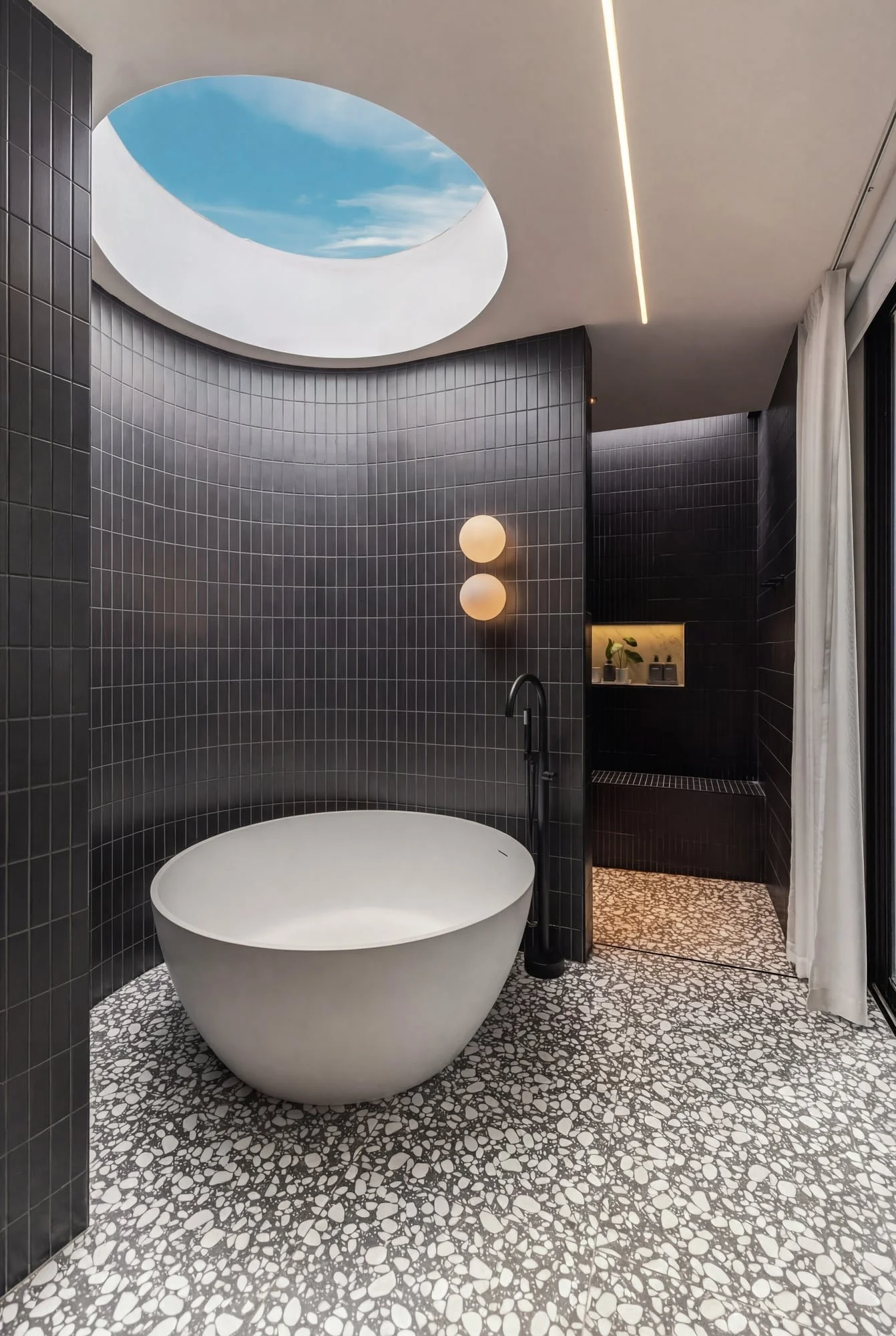 Bathroom with skylight and freestanding tub at Krono Residence