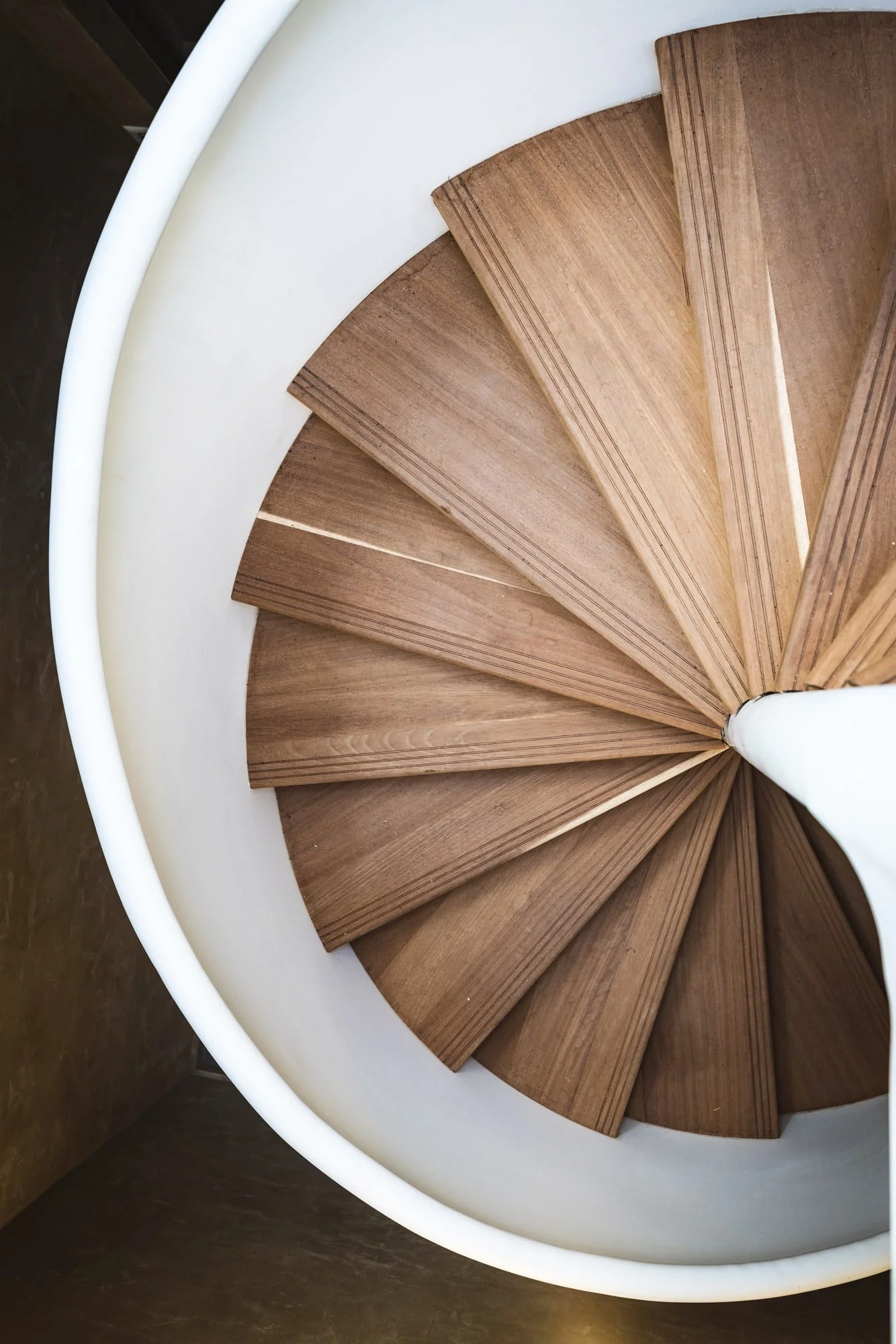 Sculptural spiral staircase with warm timber treads and white curves