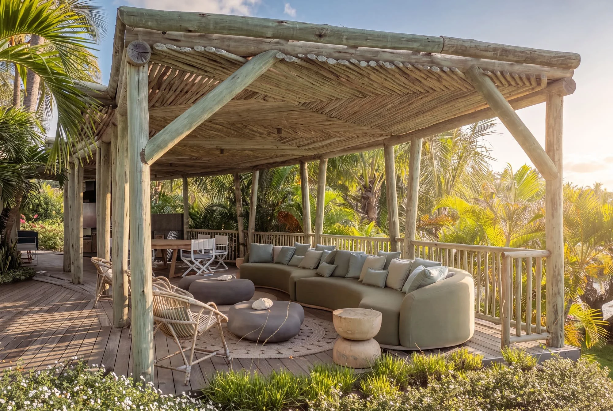 Timber pergola lounge overlooking the tropical garden at sunset