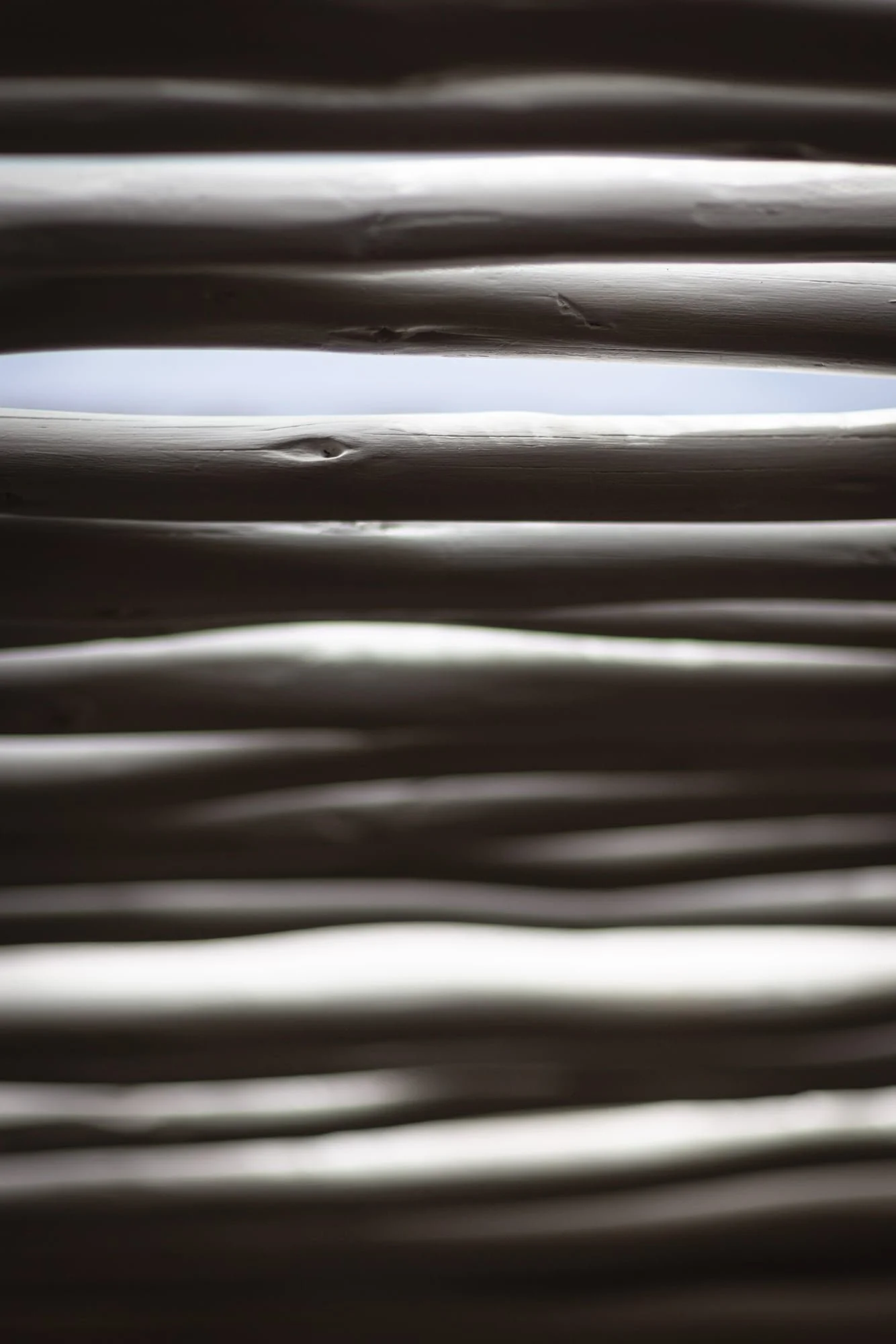 Abstract light and shadow across handcrafted timber louvres